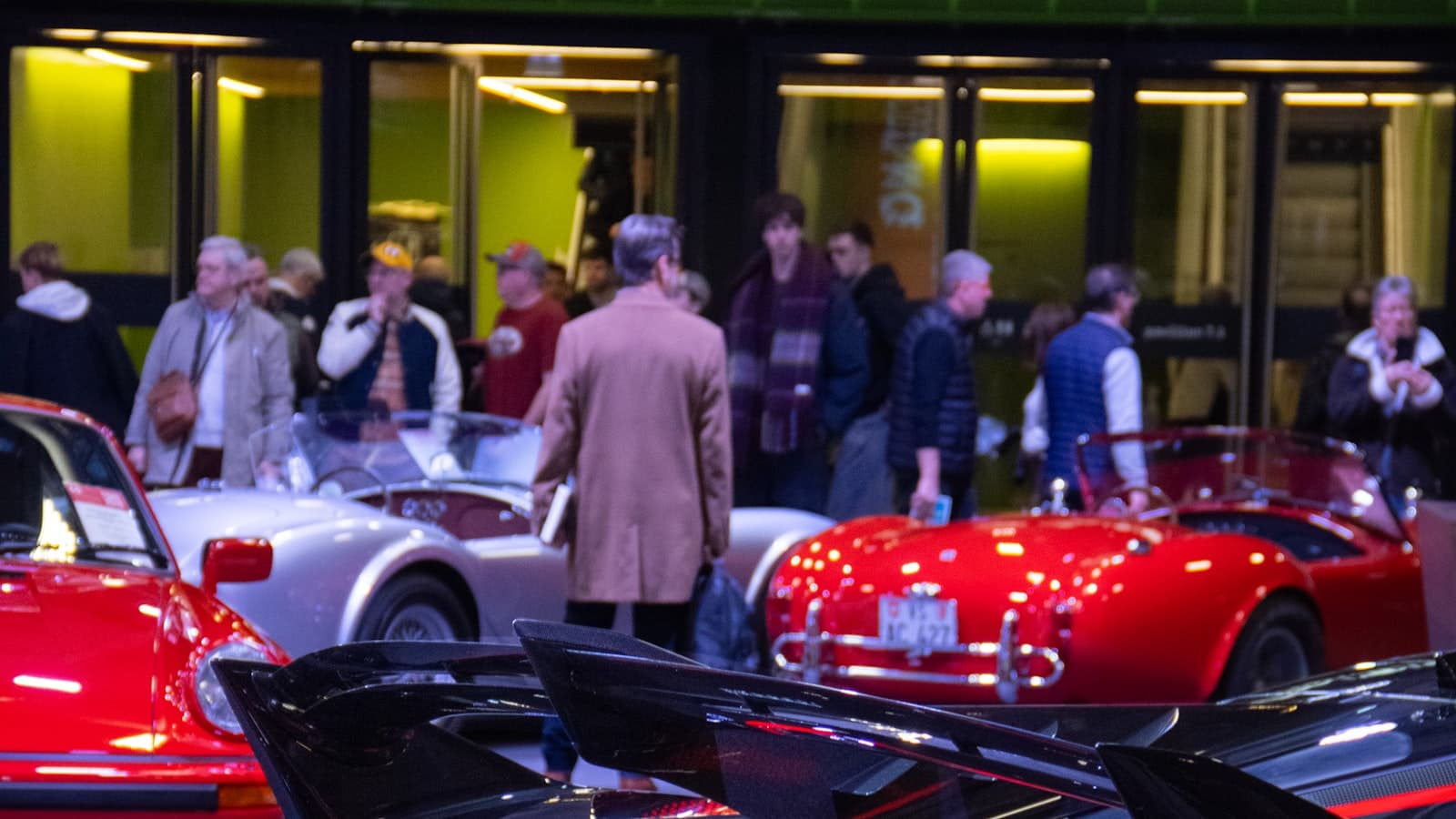 Plusieurs voitures de sport exposées lors d'un salon automobile.