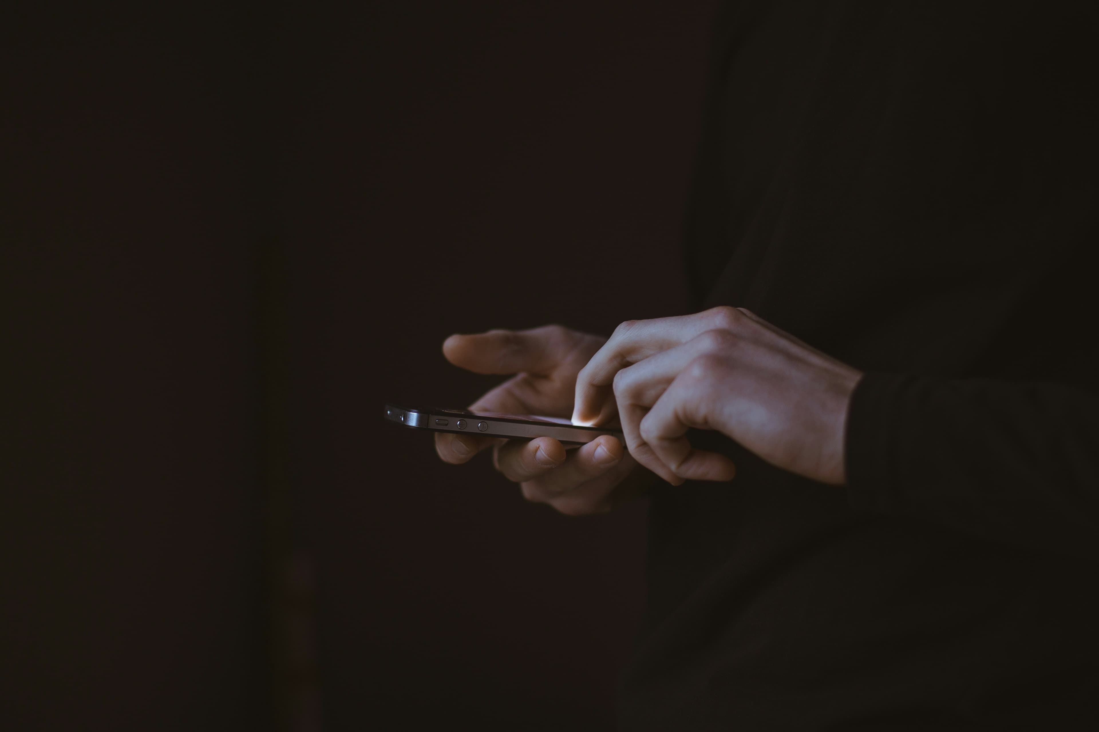 Silhouette d'une personne tenant un smartphone