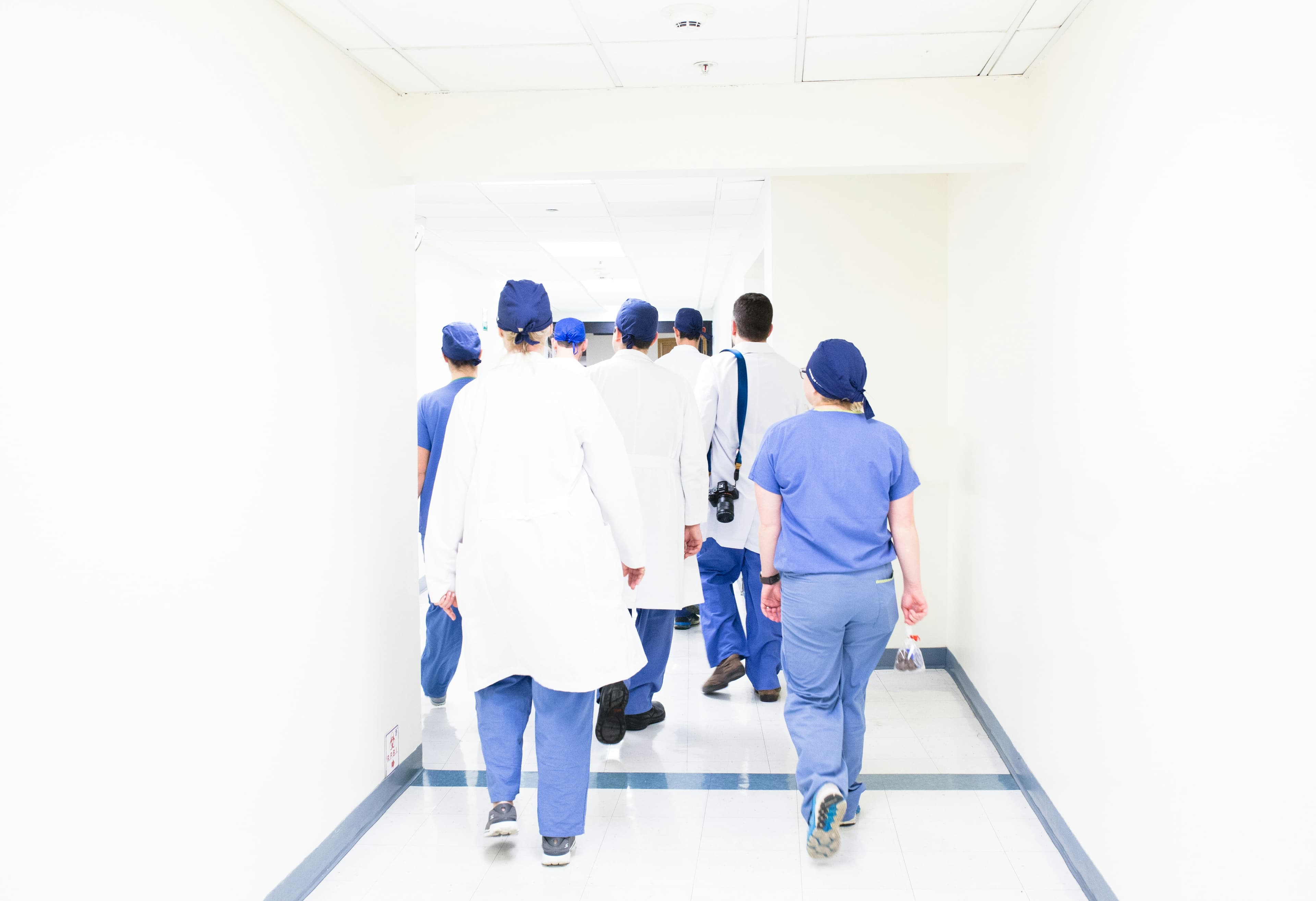 Groupe de professionnels de santé en blouse blanche dans un couloir d'hôpital