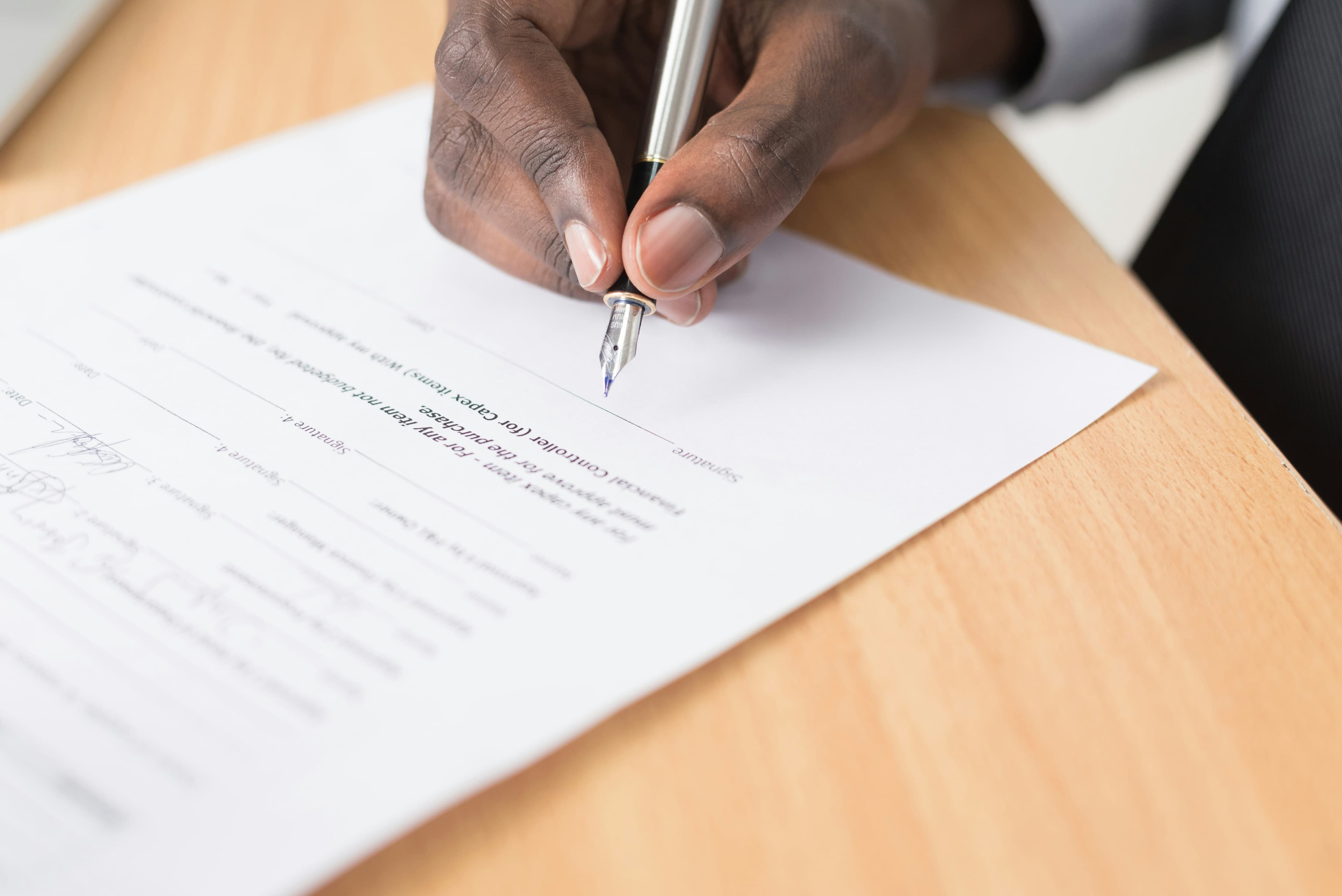 Une personne rédige un document sur une feuille blanche