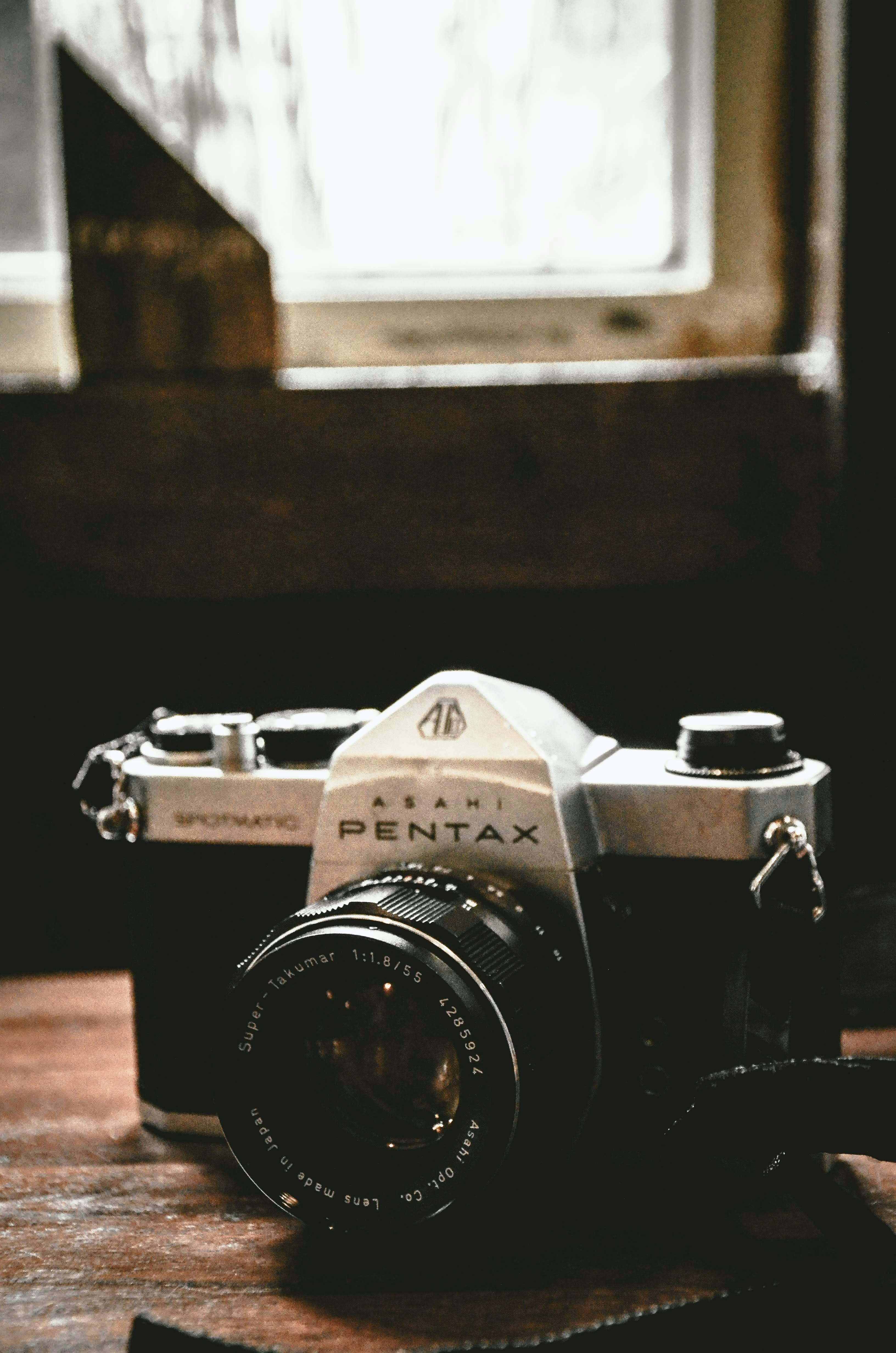 Un appareil photo argentique noir et argent posé sur une table