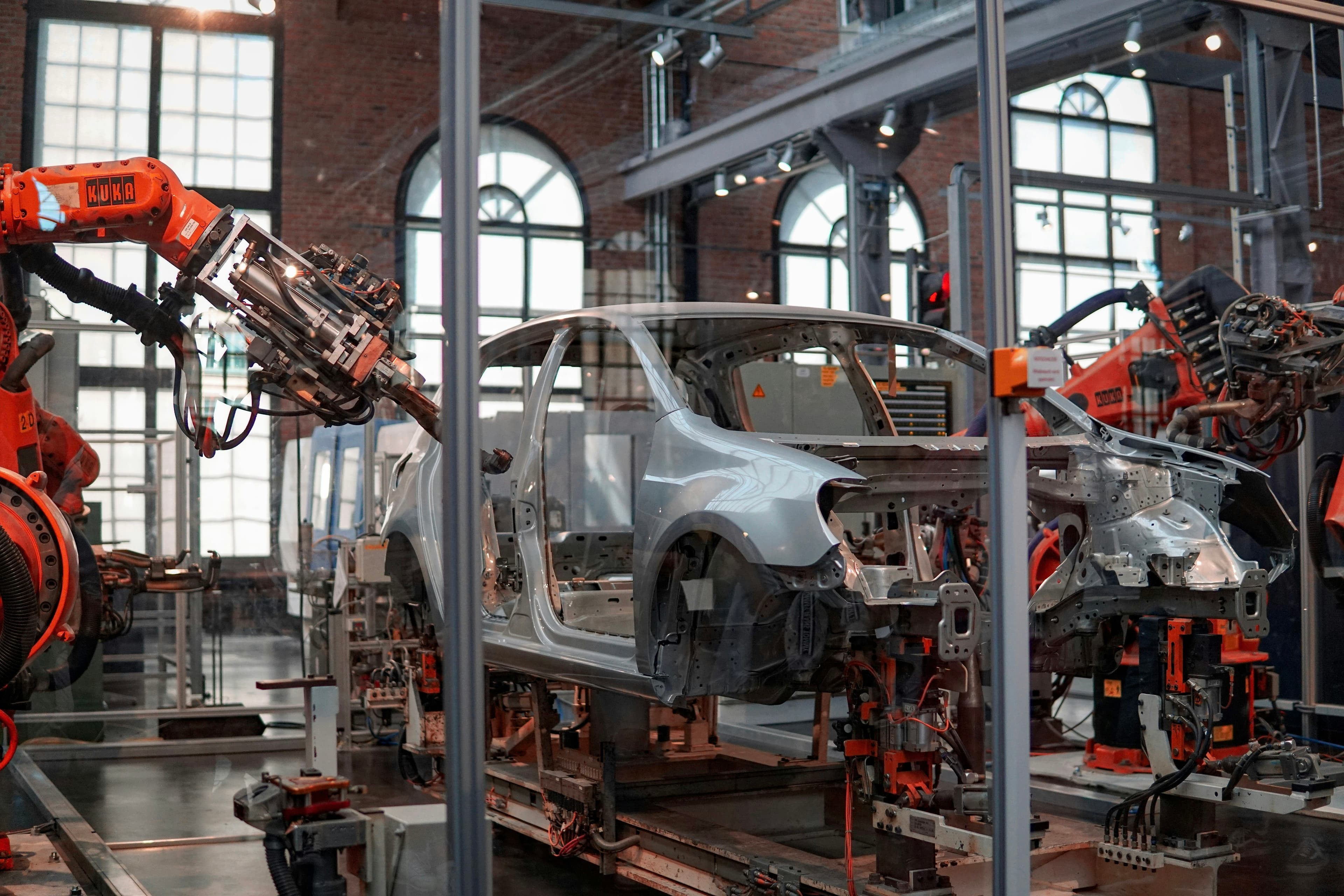 Bras robotisés assemblant une carrosserie de voiture sur une chaîne de montage industrielle