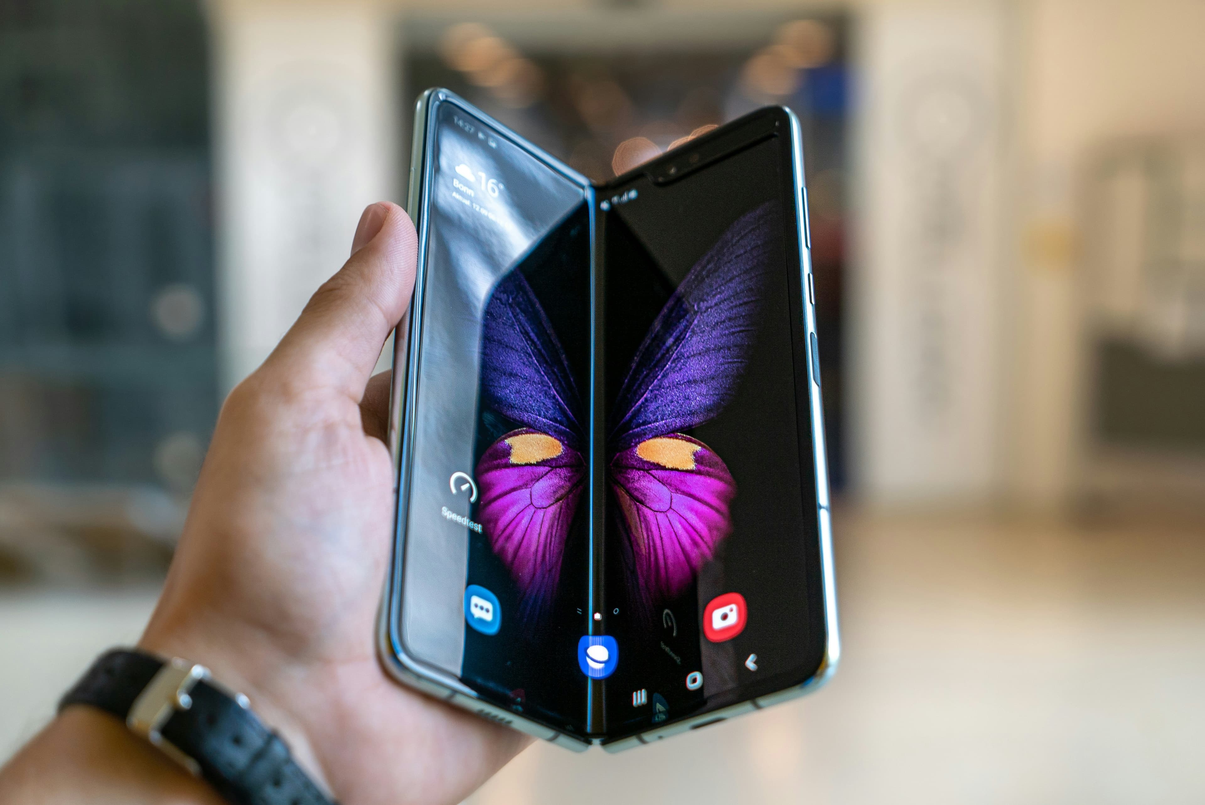 Main tenant un smartphone pliable replié