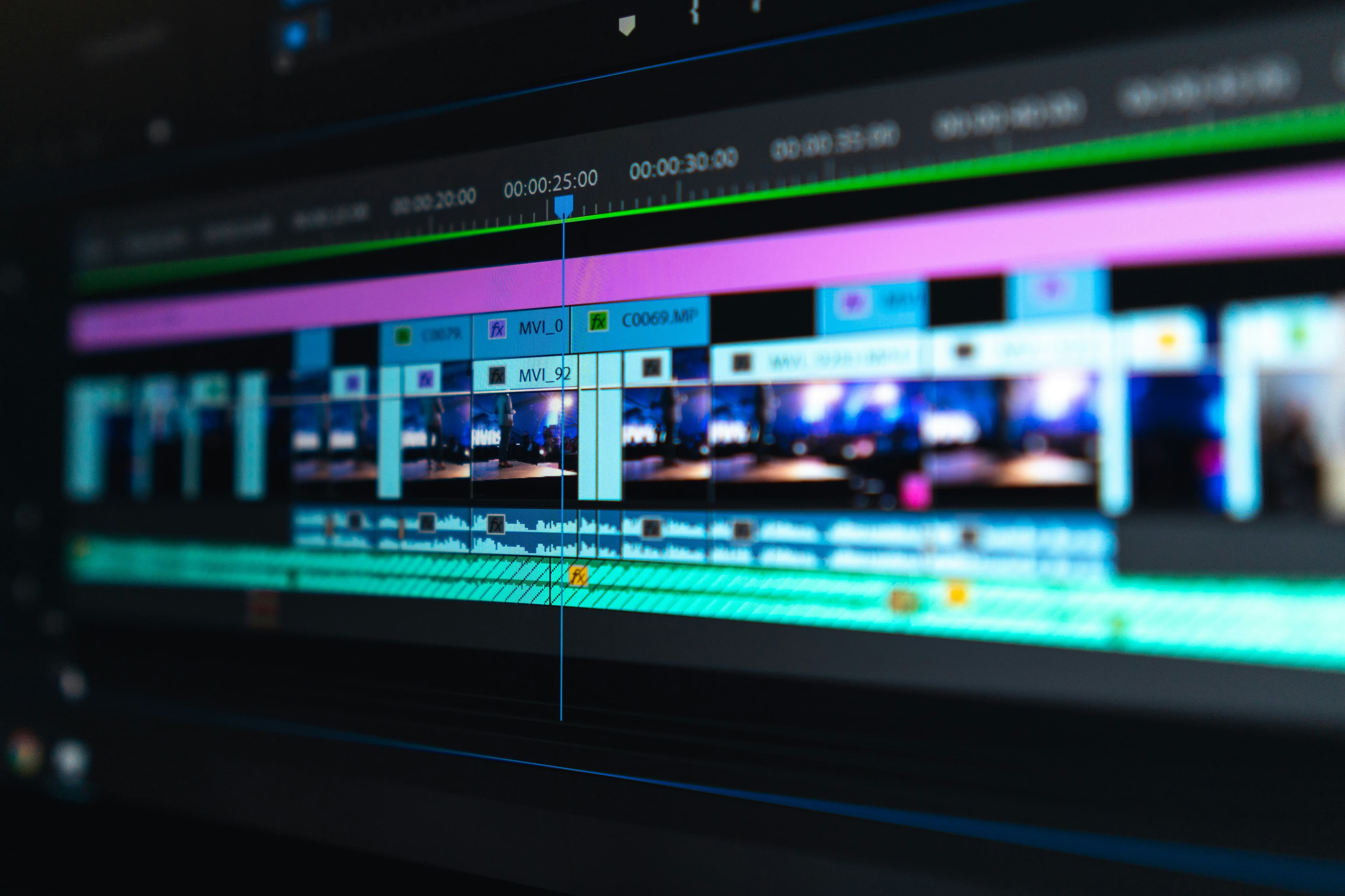 Une timeline de montage vidéo avec des clips bleus et violets sur un écran sombre