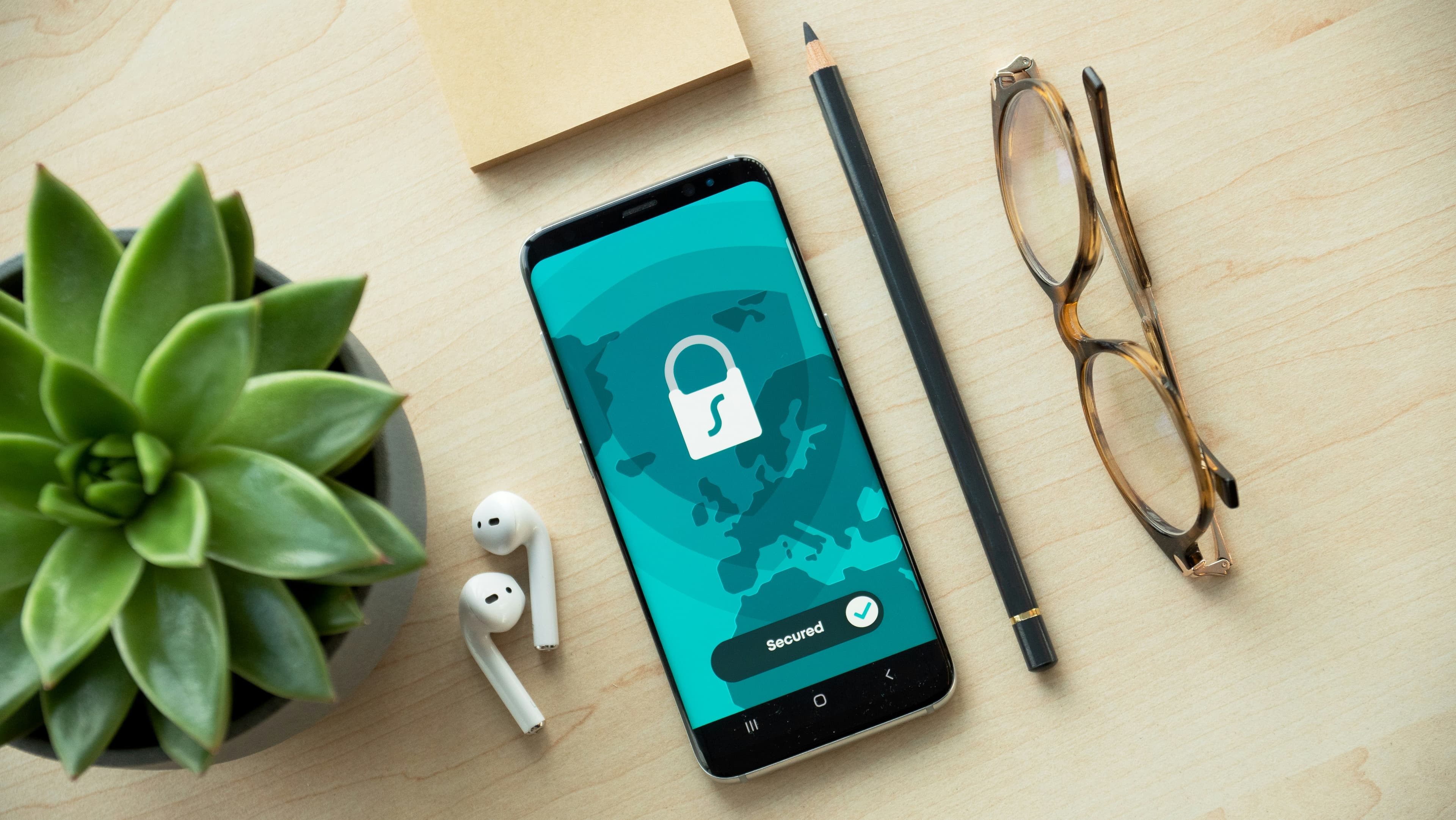 Smartphone affichant une icône de verrouillage de sécurité posé sur un bureau en bois