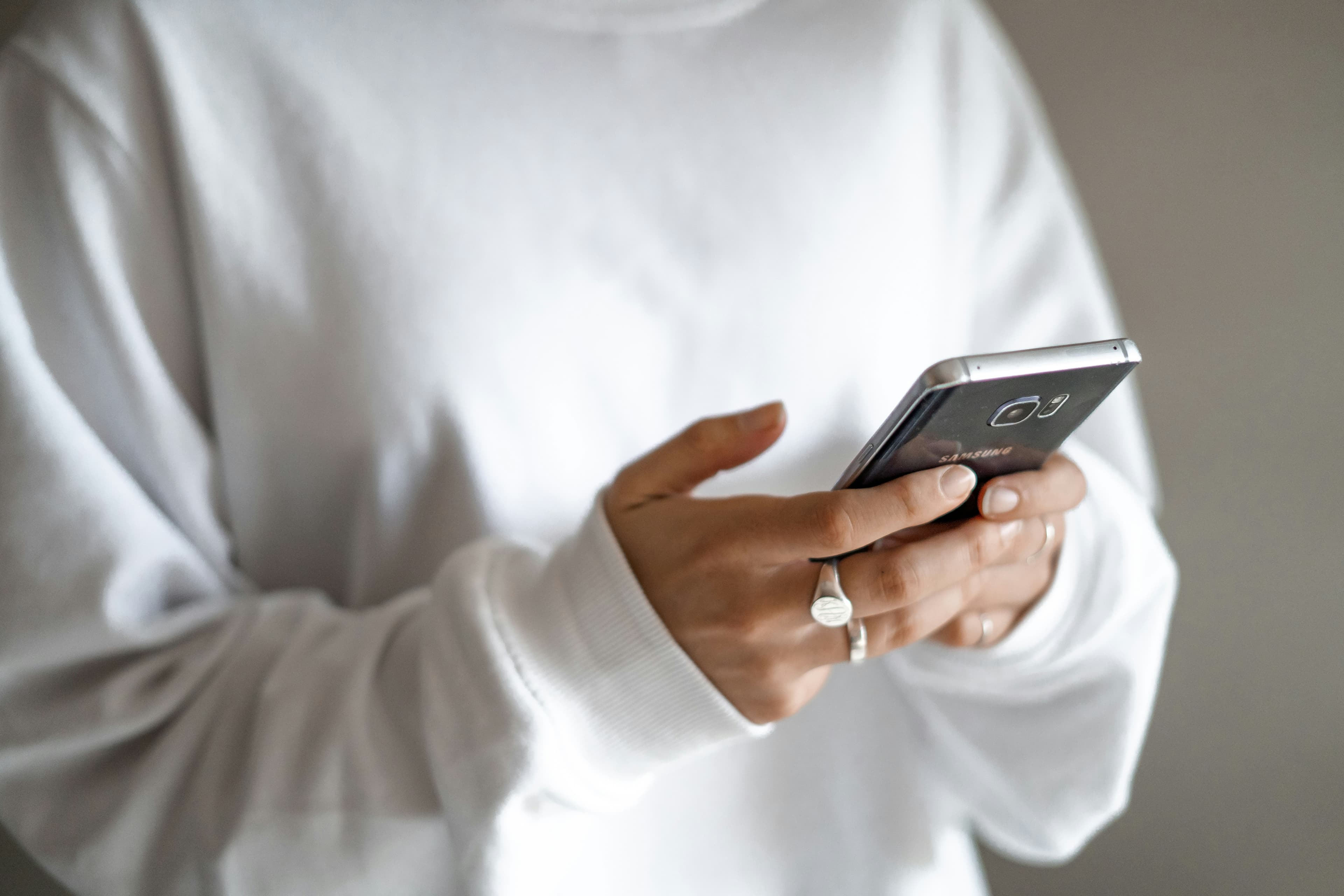 Personne tenant un smartphone noir dans sa main