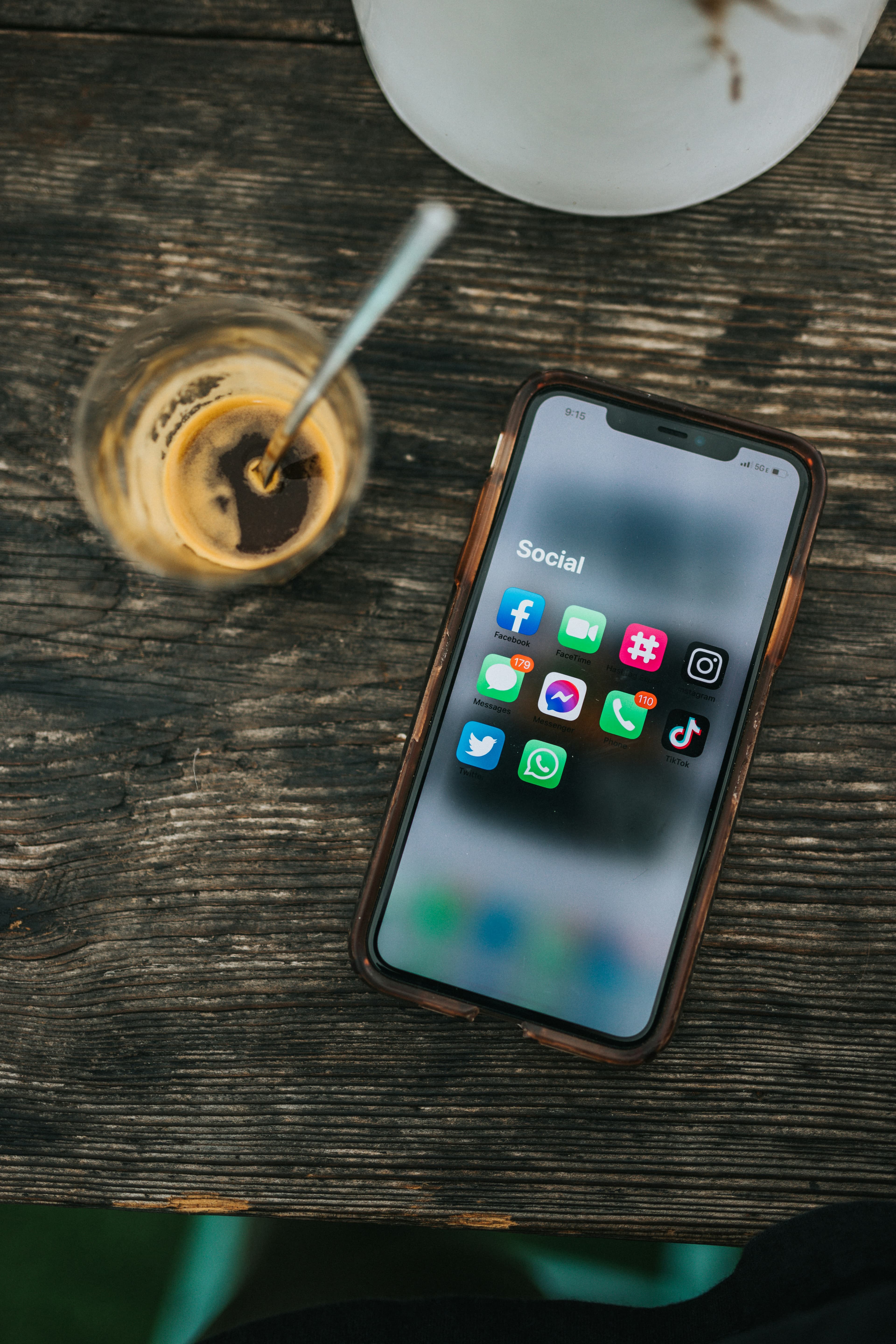 Un smartphone affichant des applications de réseaux sociaux posé près d'un café