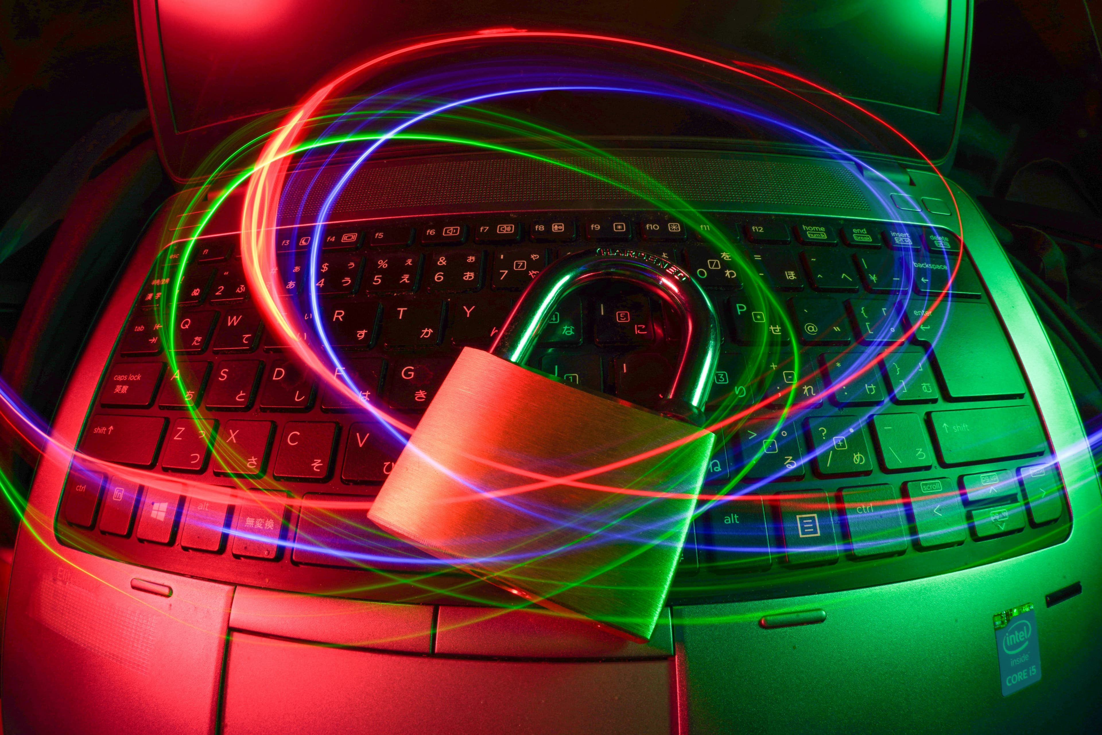Cadenas posé sur un ordinateur portable avec des traînées de lumière évoquant un réseau