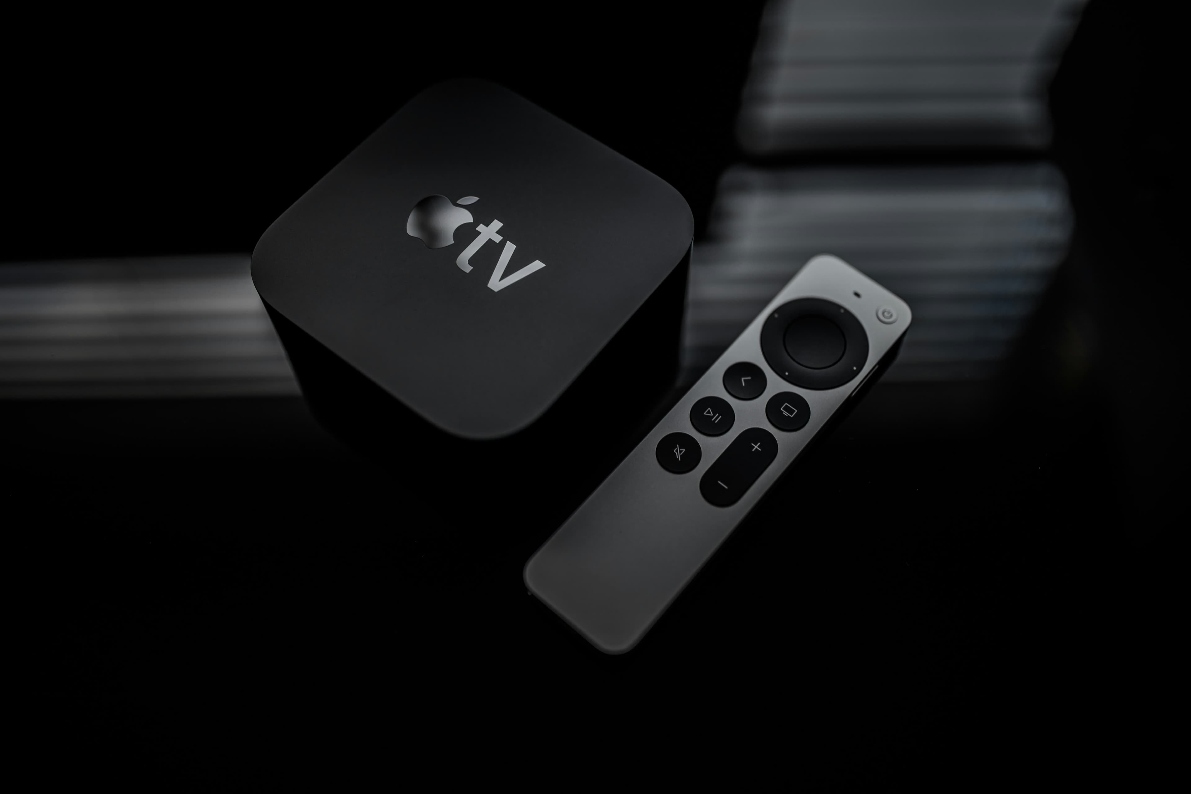 Télécommande Apple TV noire posée sur une surface claire