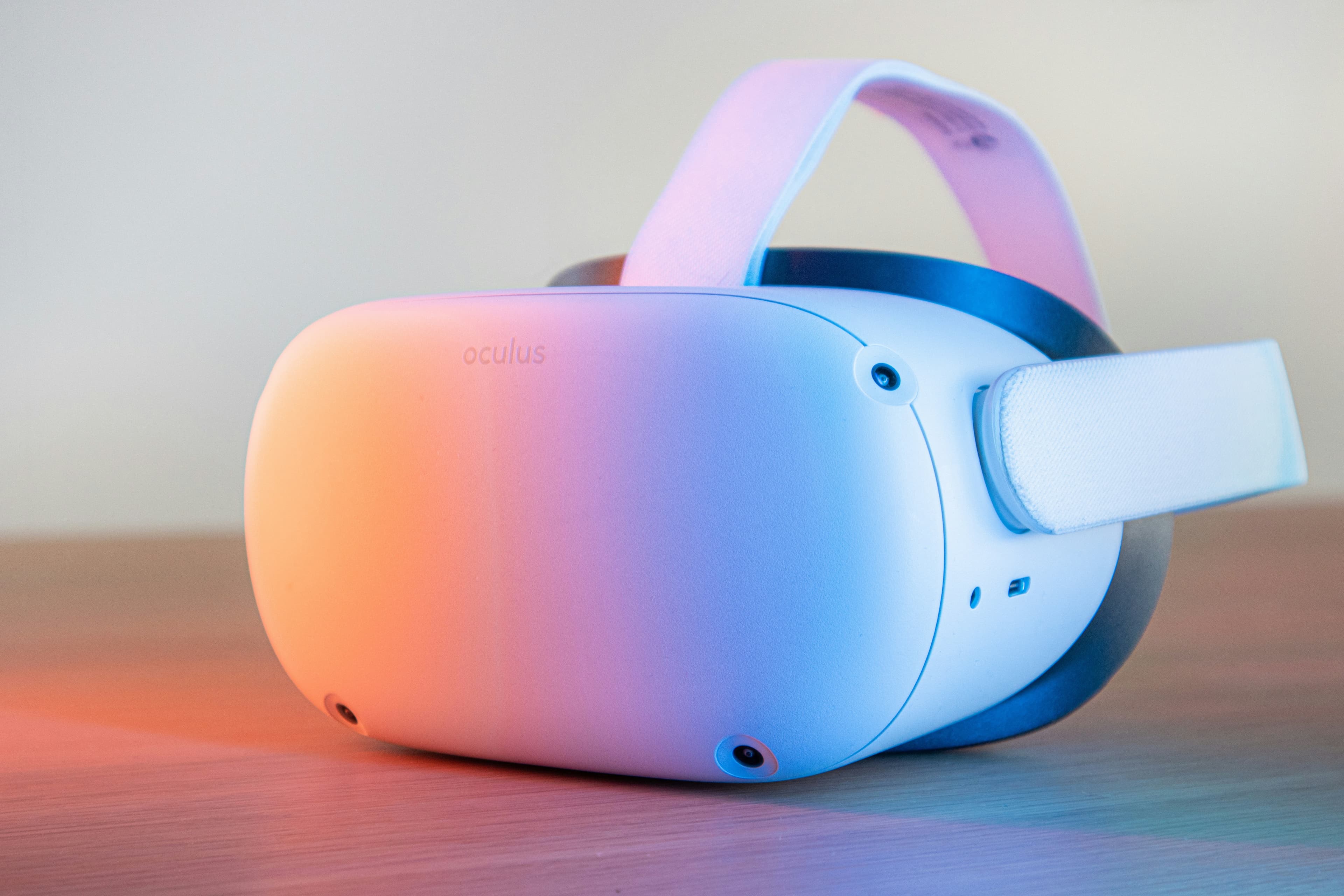 Casque de réalité virtuelle rose et blanc tenu à la main