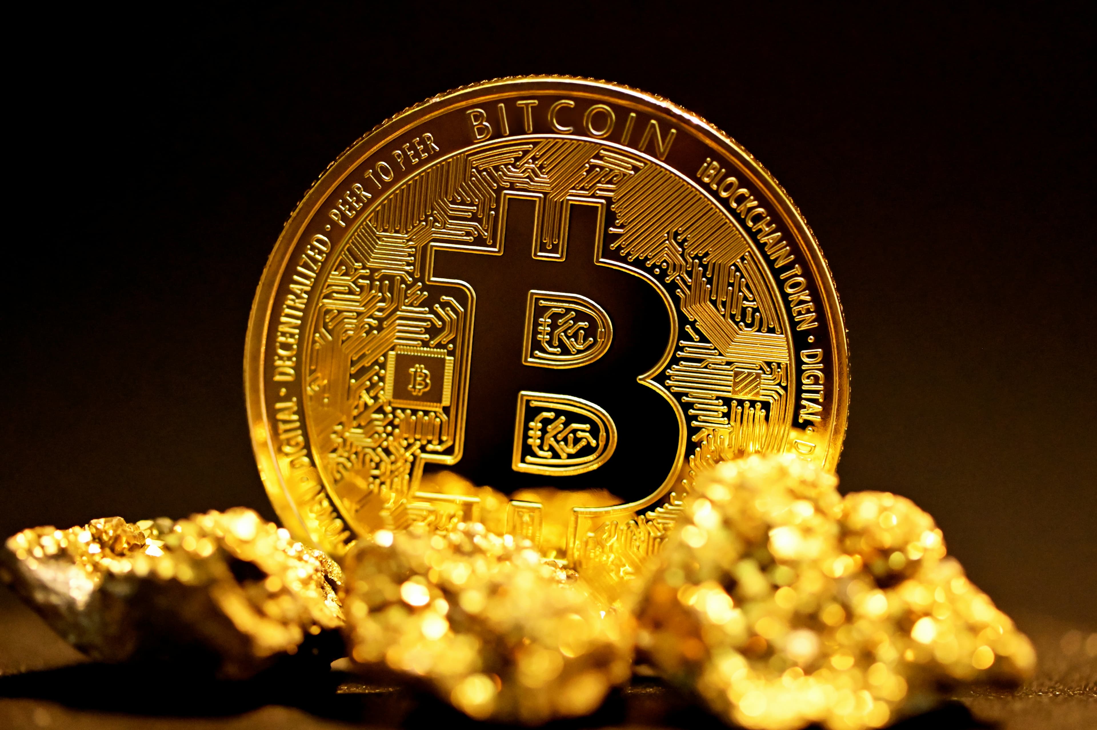 Pièce de bitcoin posée sur un tas de pépites dorées