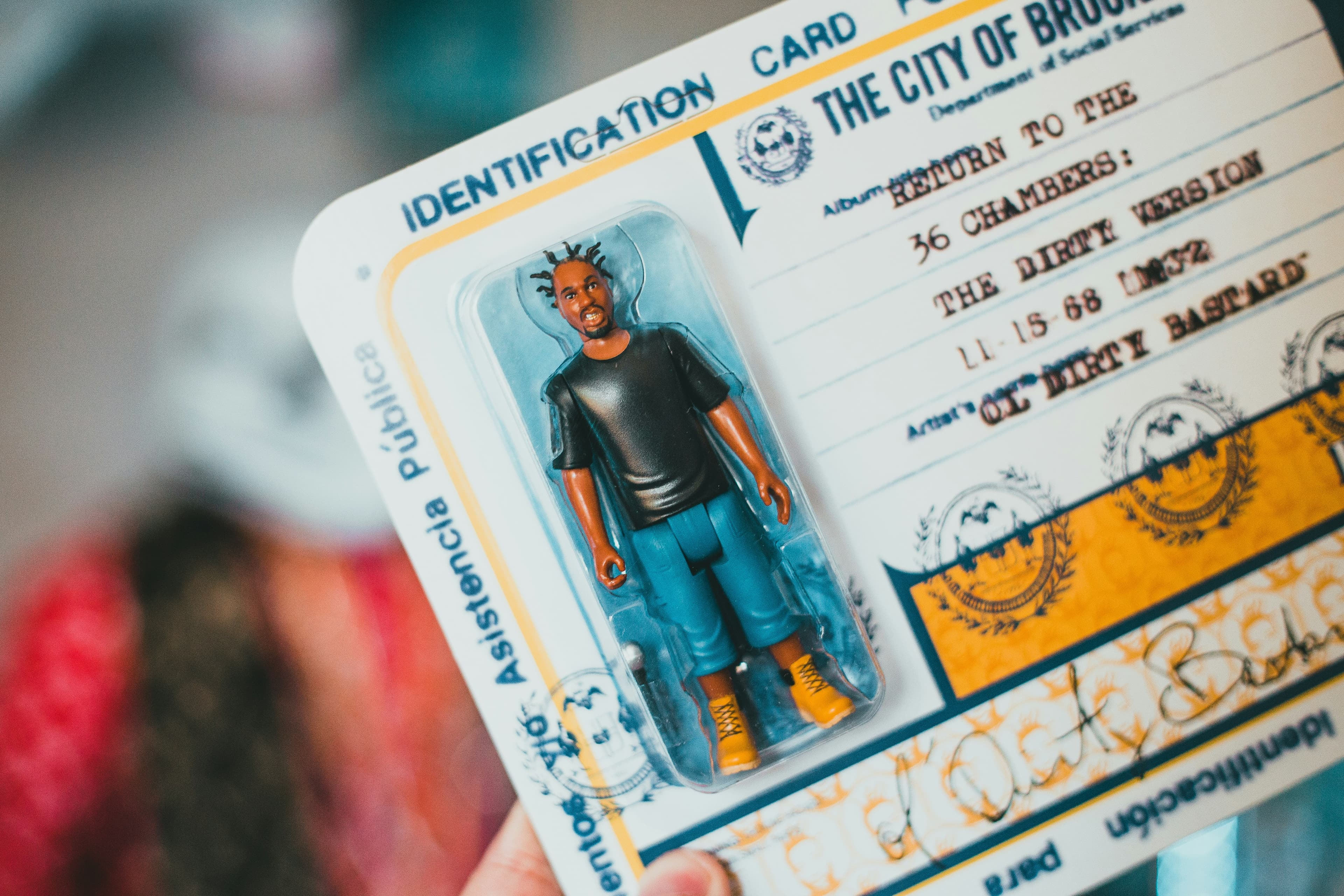 Main tenant une carte d'identification blanche et bleue