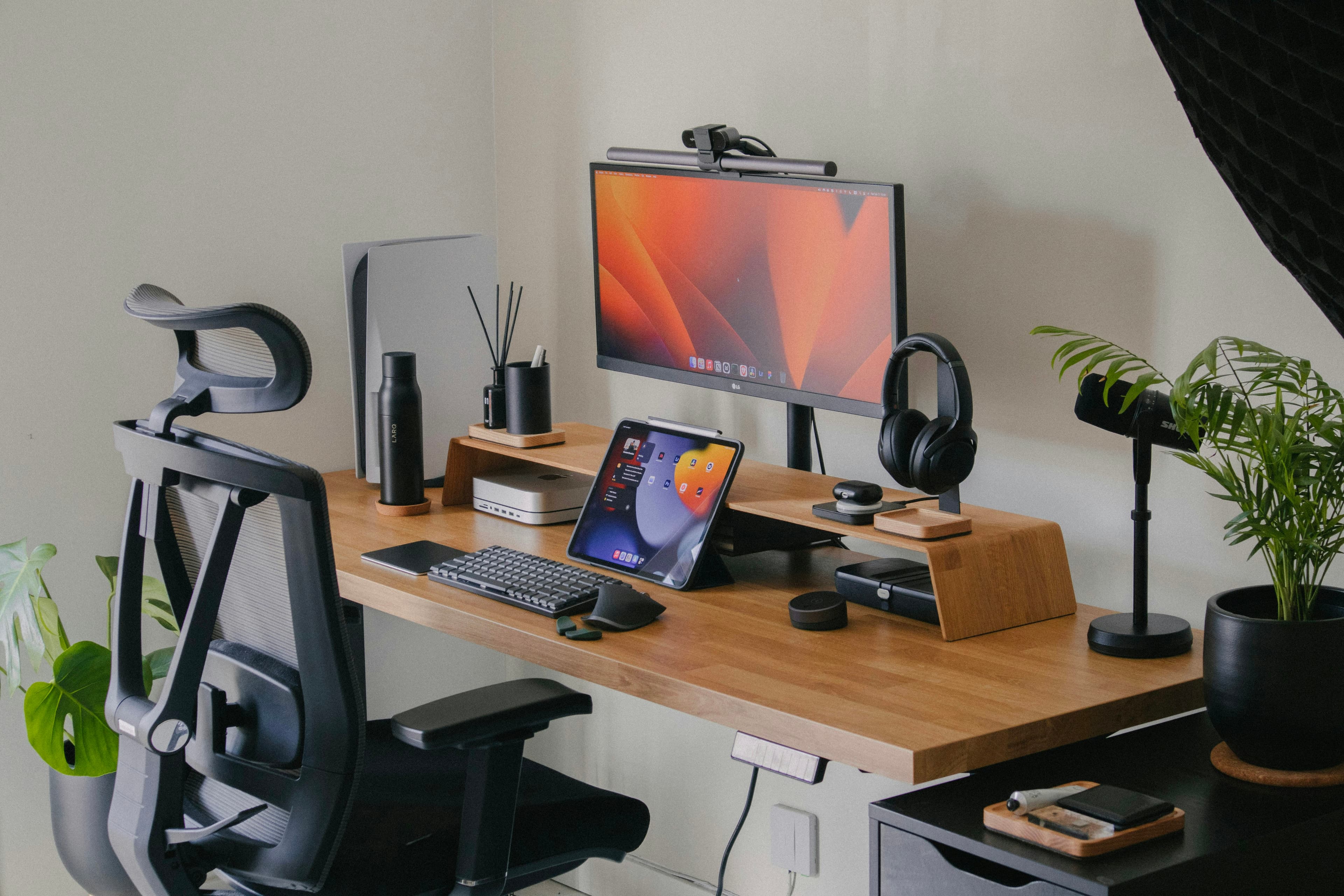 Un bureau en bois avec un écran d'ordinateur et un clavier