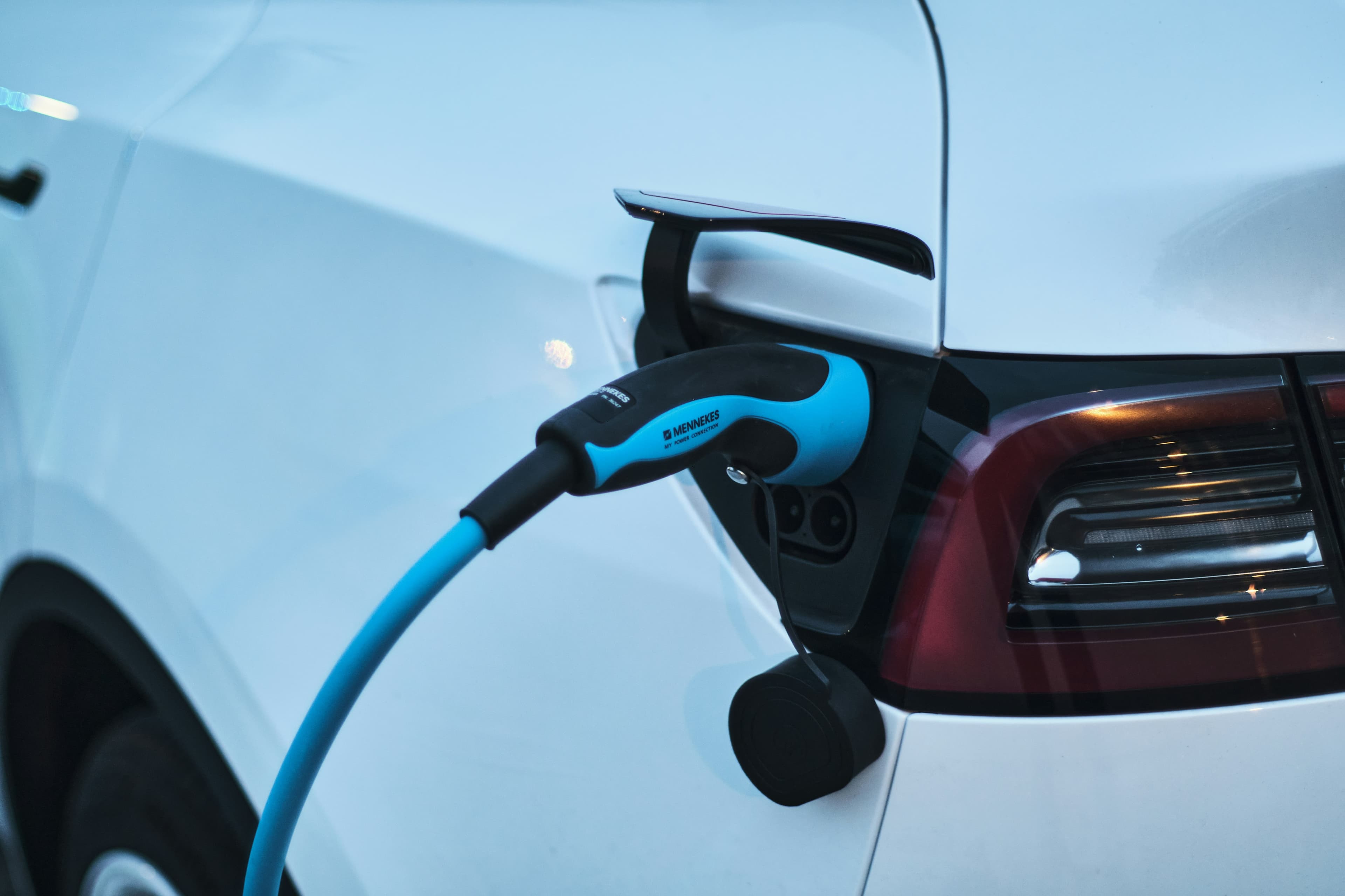 Câble de recharge branché sur une petite voiture électrique citadine