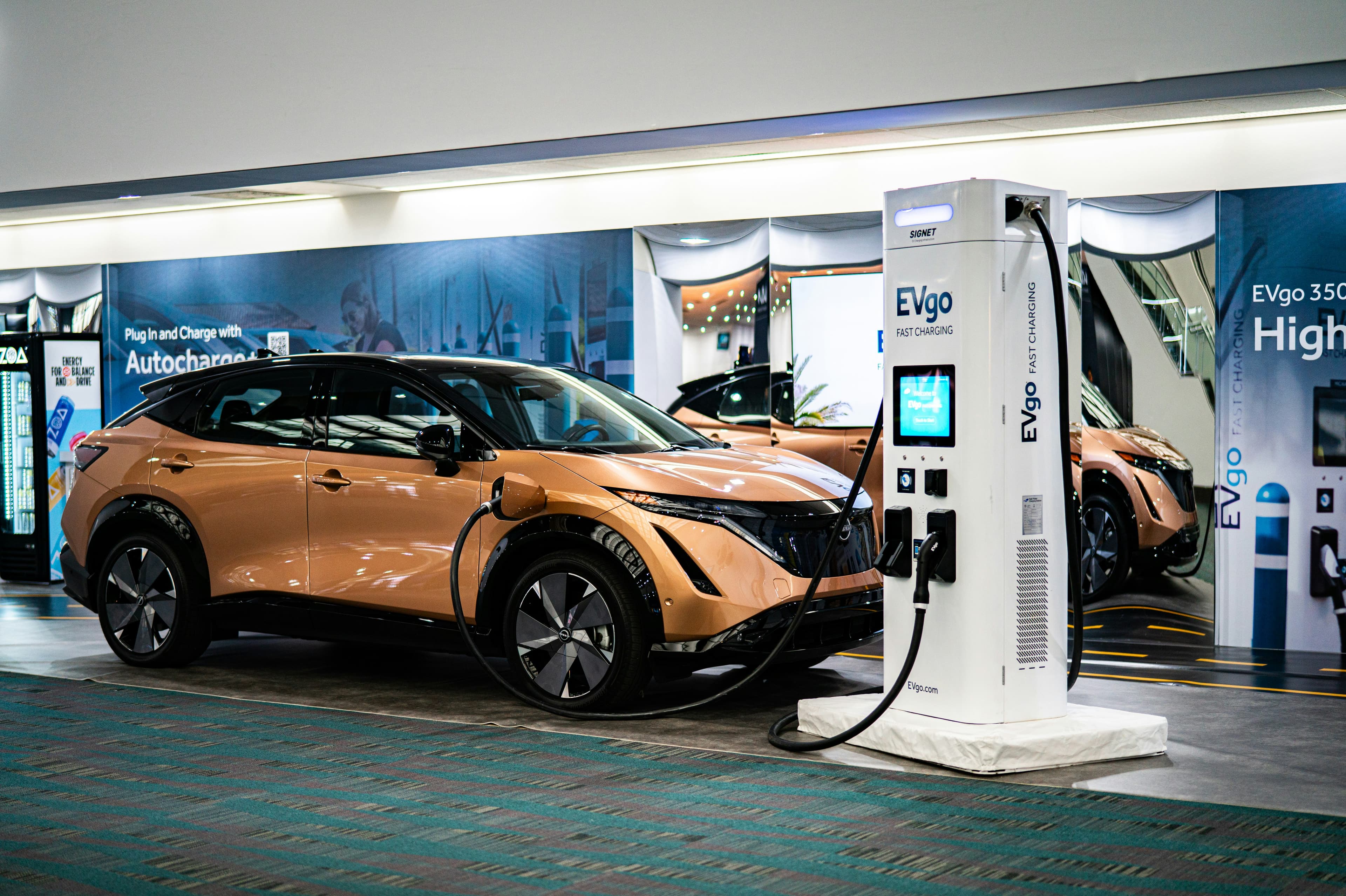 Véhicule électrique branché à une borne de recharge lors d'un salon automobile