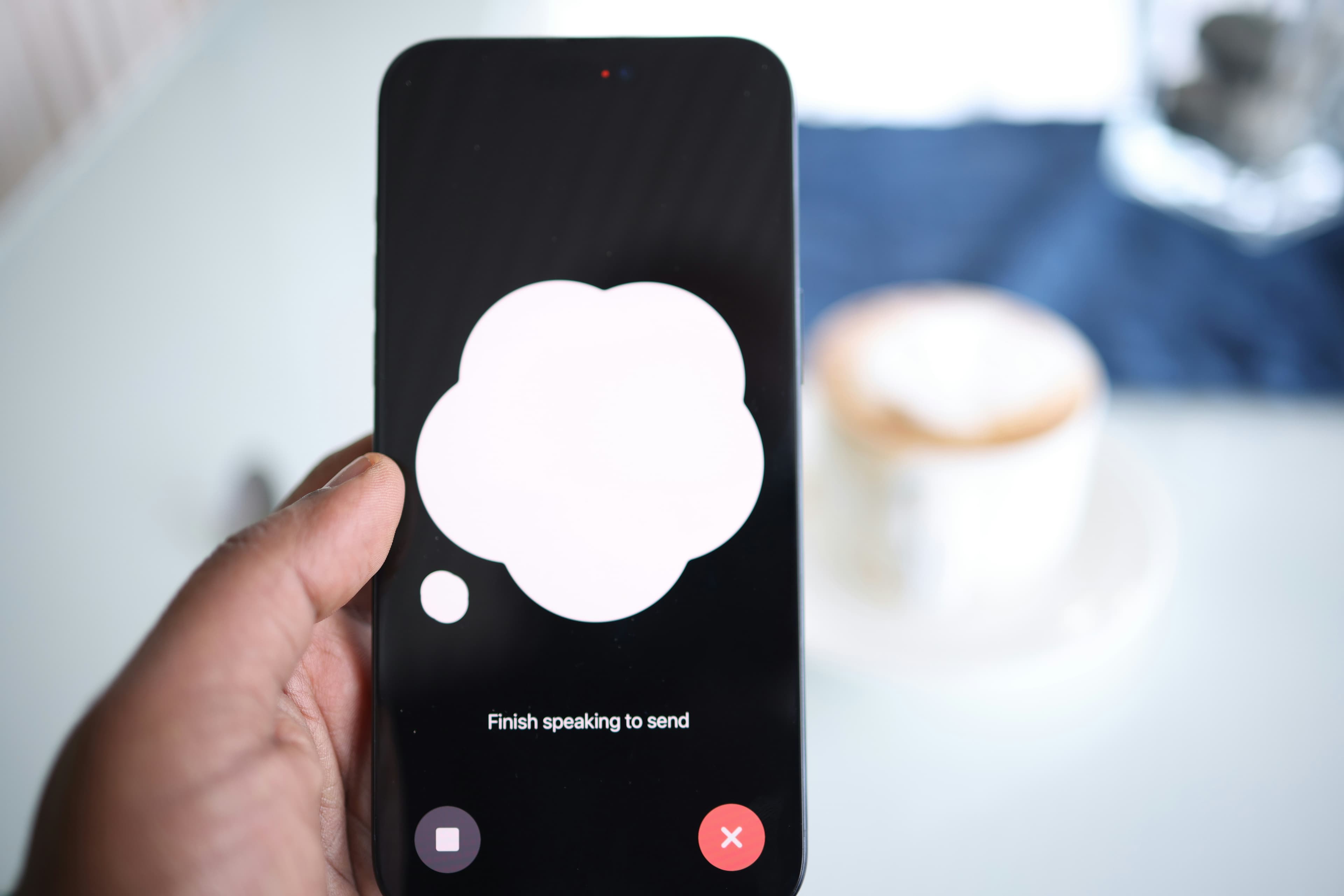 Main tenant un smartphone affichant une bulle de message sur fond d'écran sombre