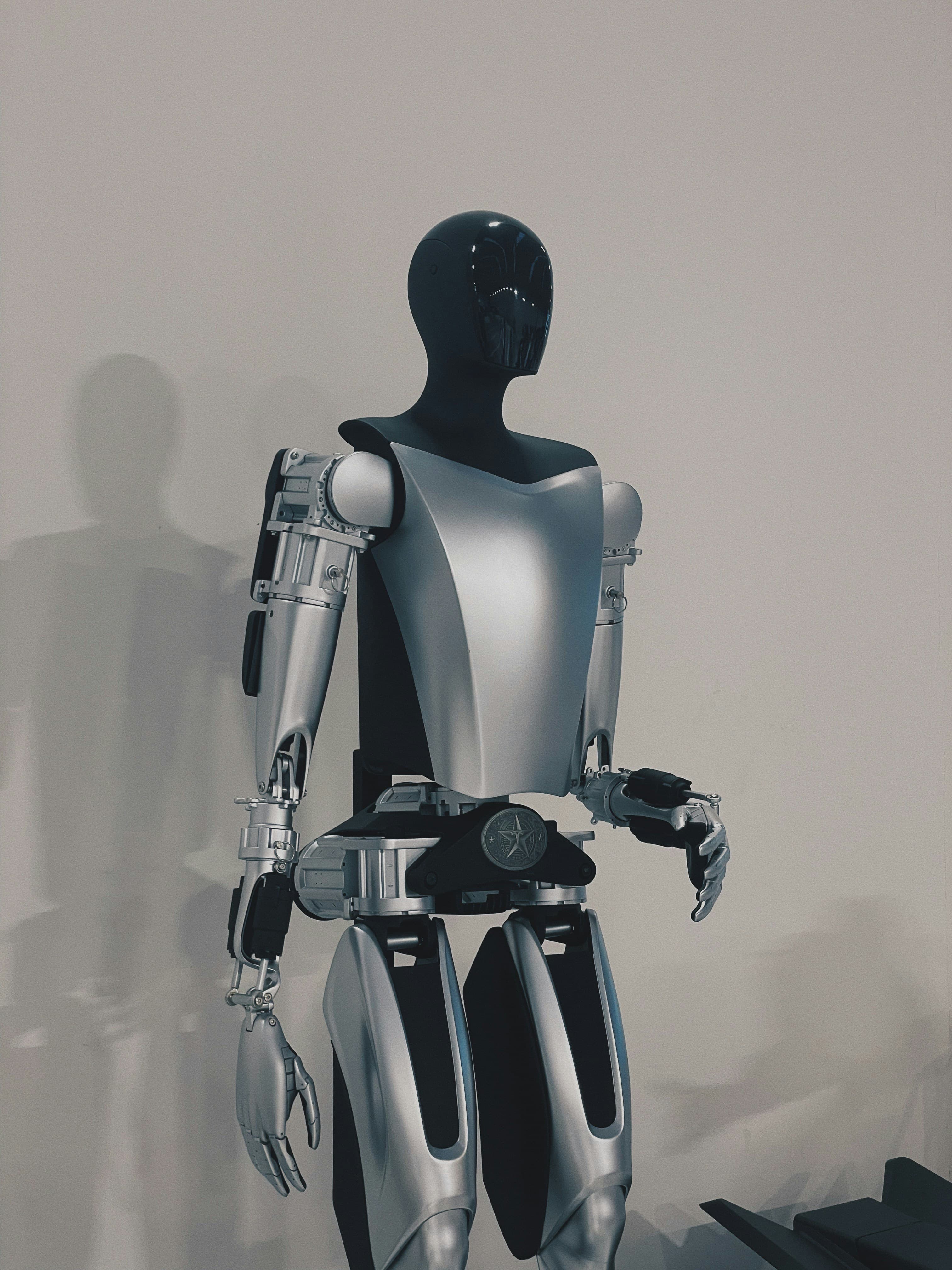 Un robot humanoïde blanc se tenant devant un mur blanc