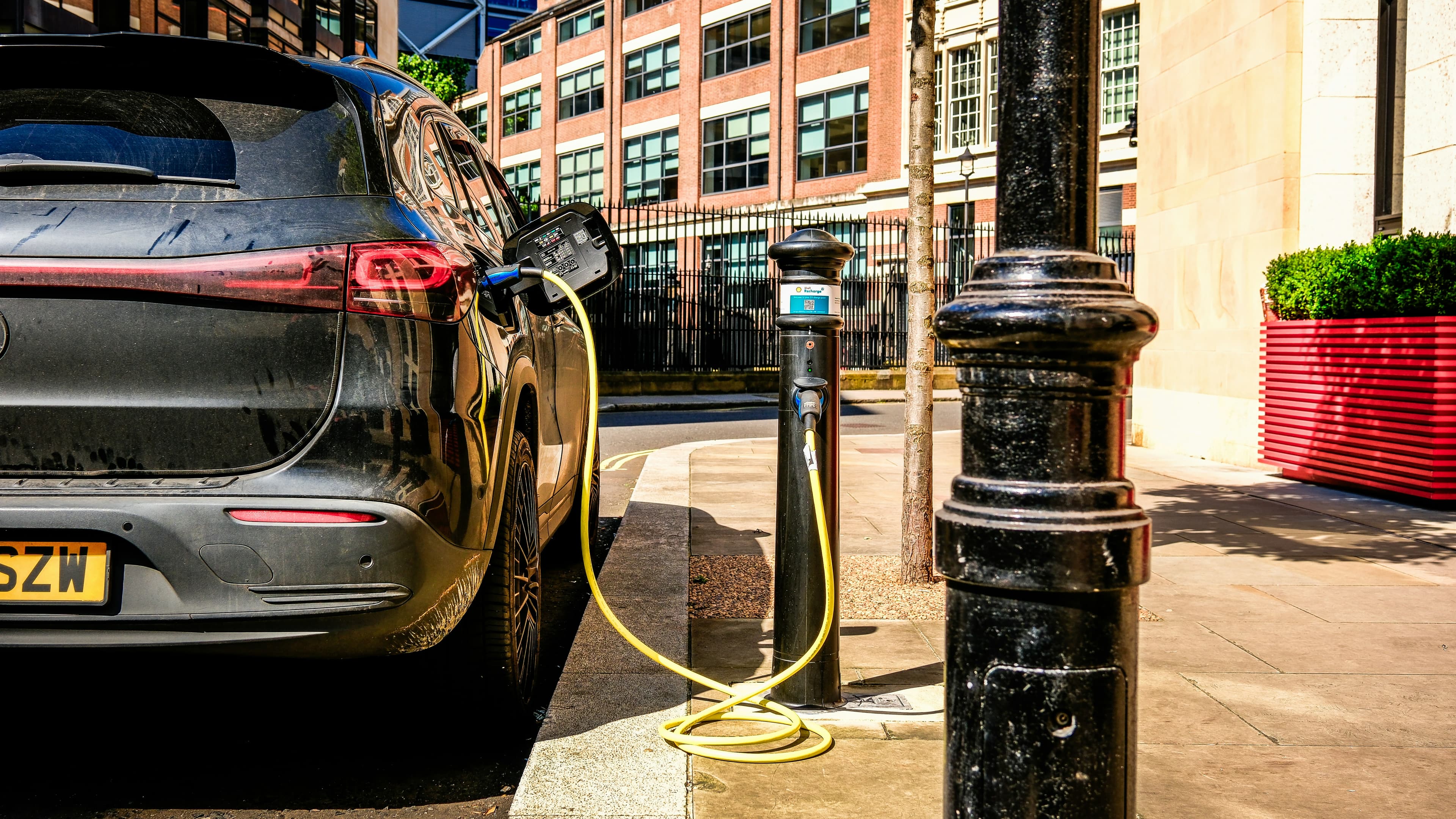 Une voiture électrique branchée à une borne de recharge dans la rue