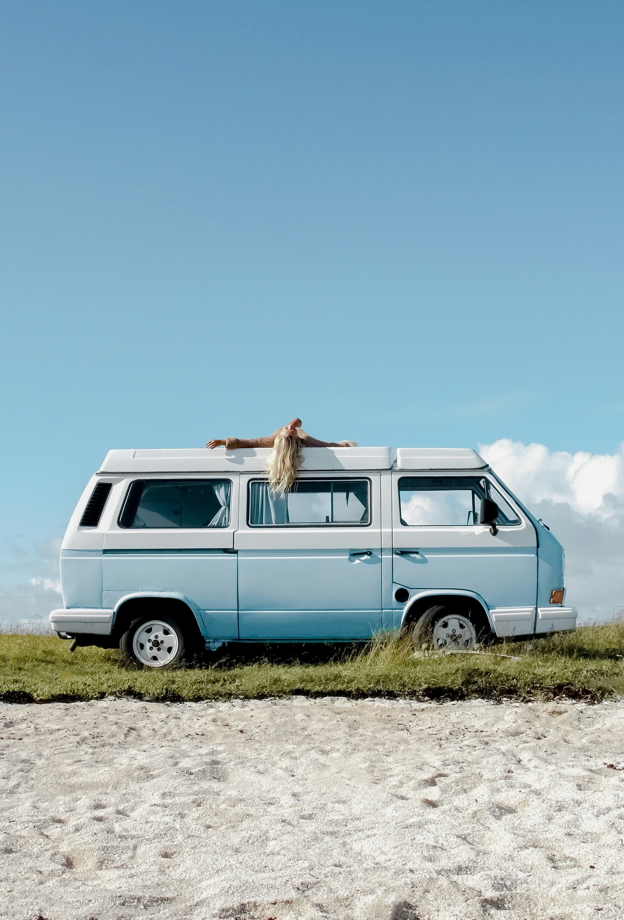 Van Volkswagen bleu garé sur une prairie herbeuse