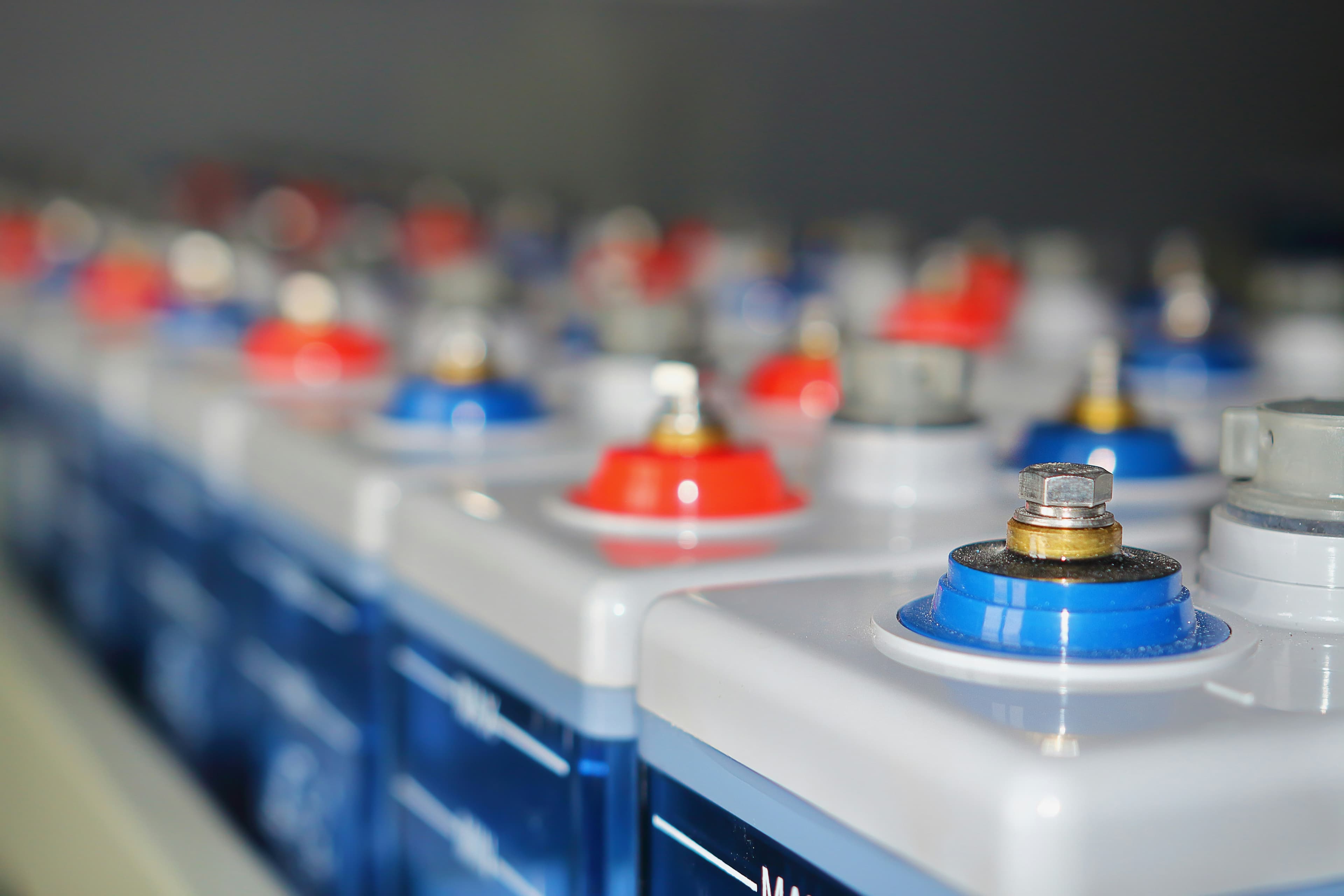 Rangées de batteries industrielles avec bornes rouges et bleues
