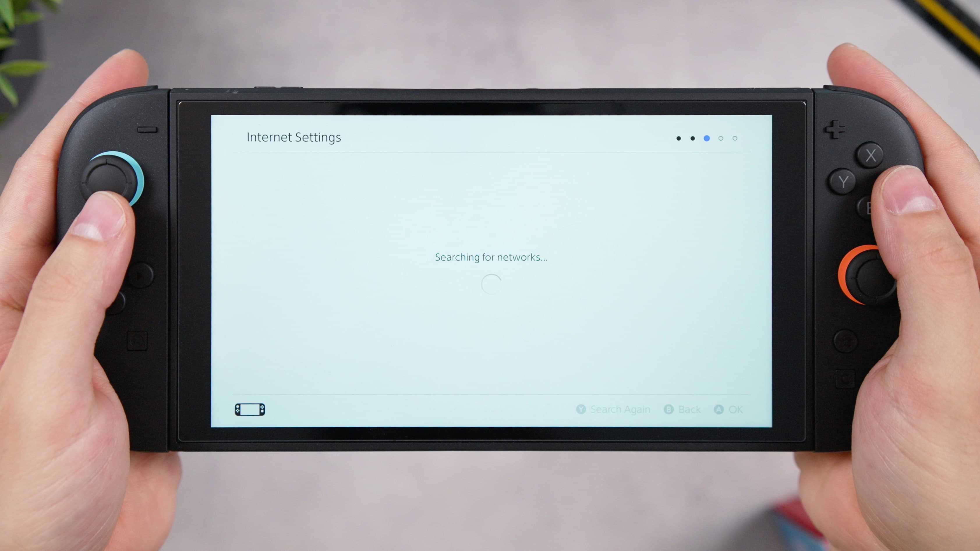 Mains tenant une console de jeu vidéo portable
