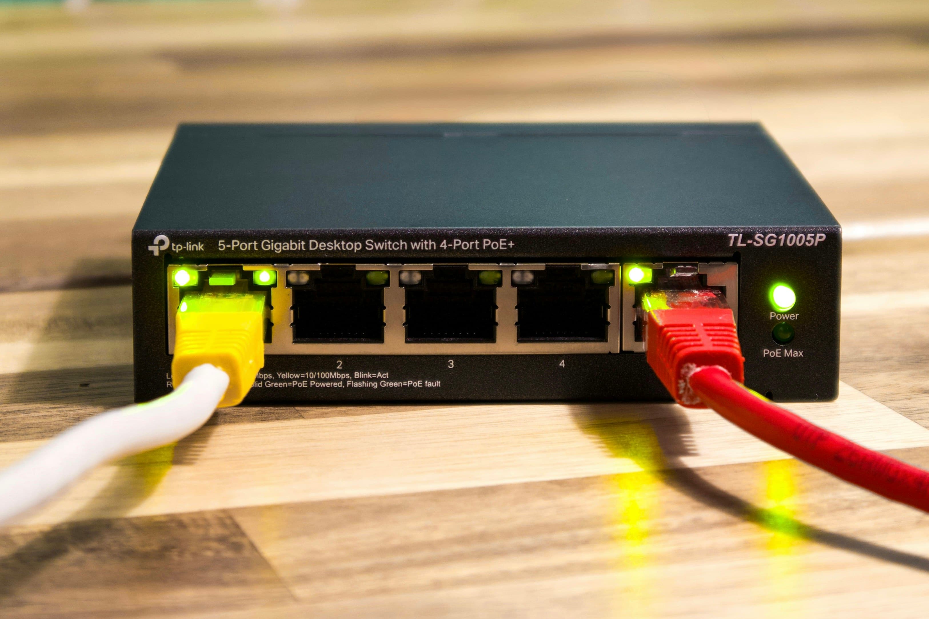 Commutateur réseau noir avec plusieurs câbles Ethernet branchés