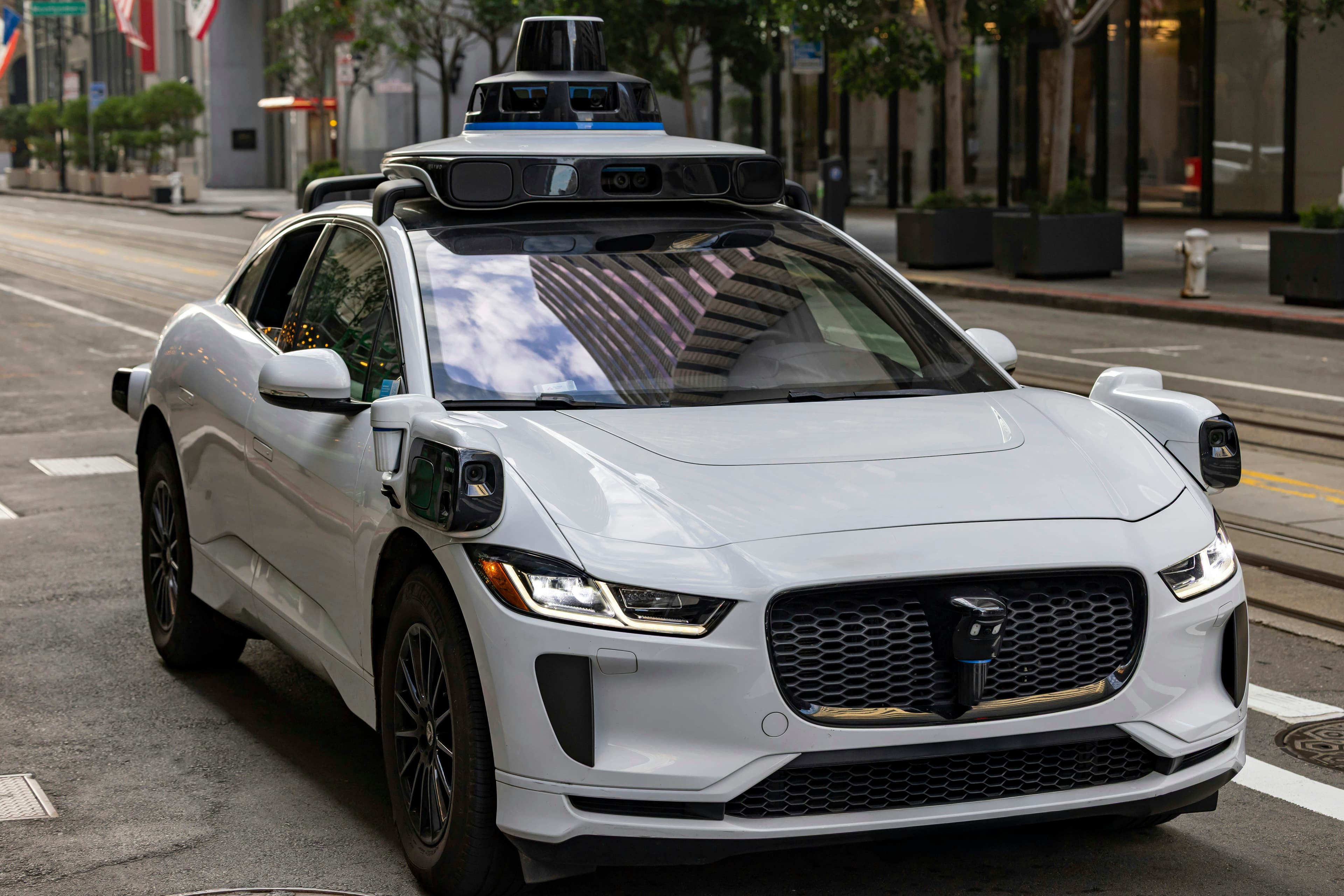 Voiture autonome blanche circulant dans une rue en ville