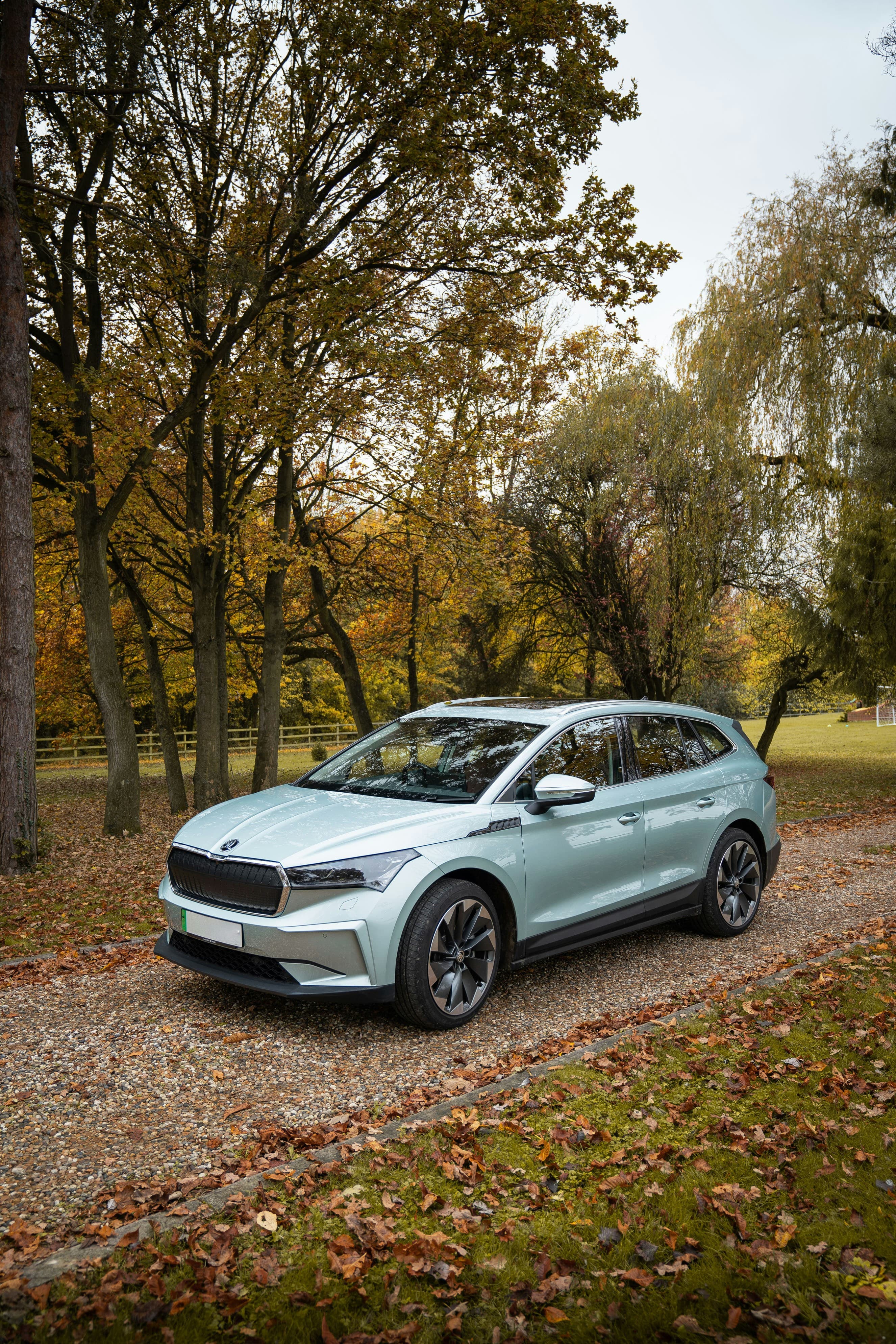 SUV électrique bleu clair stationné sur un chemin de gravier en extérieur