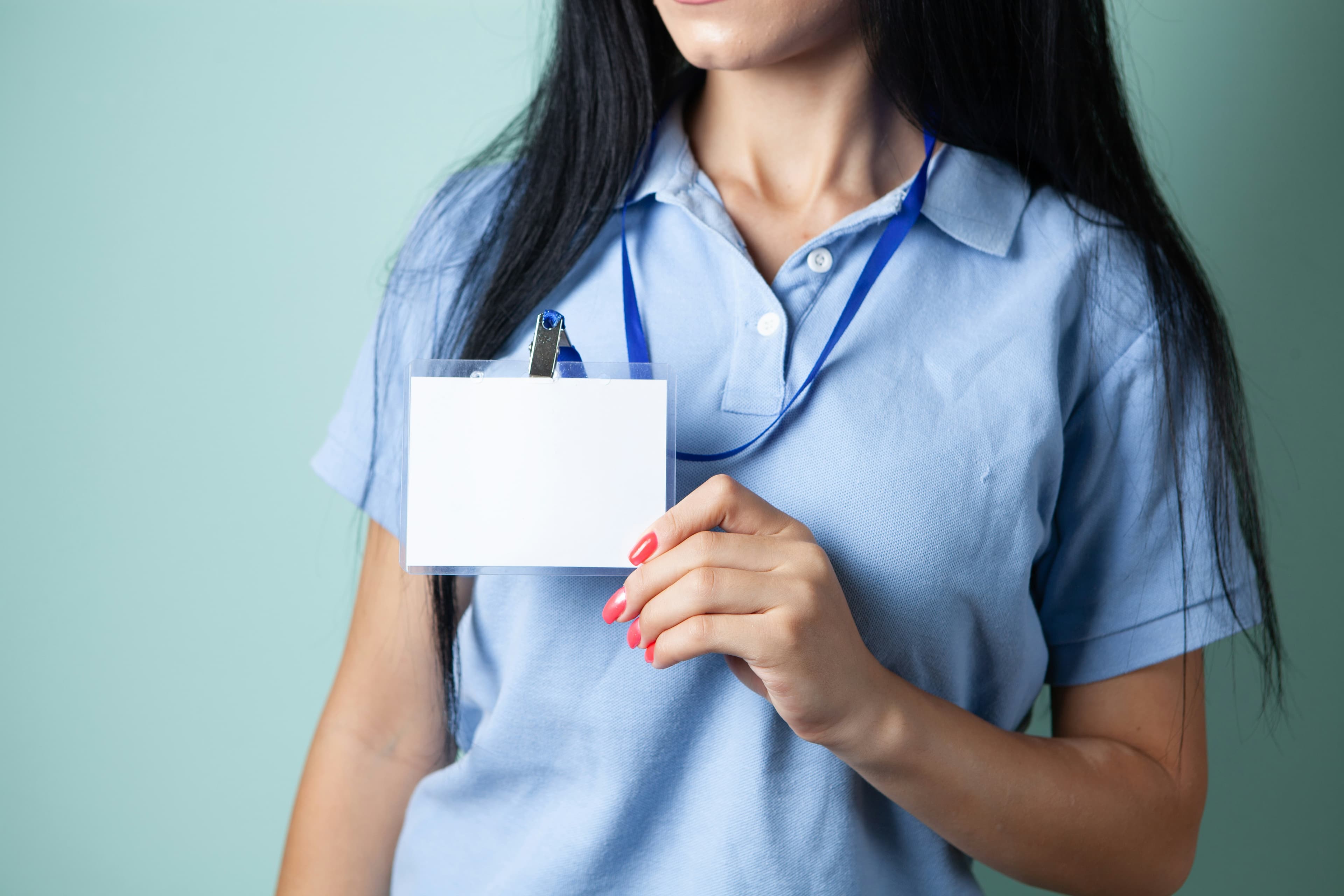 Une personne tient une carte d'identité blanche vierge dans ses mains