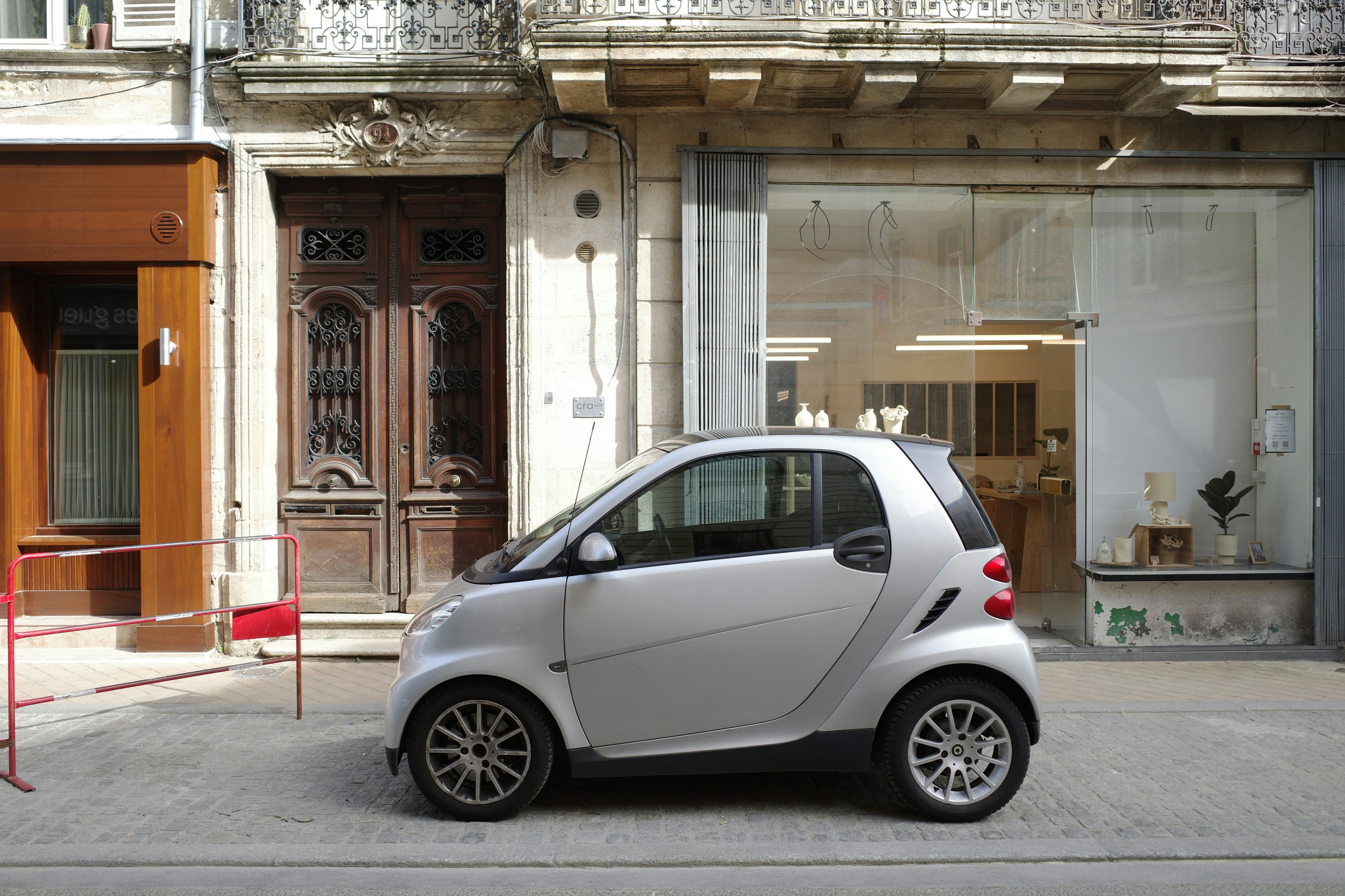 Une petite citadine électrique argentée garée dans une rue urbaine européenne
