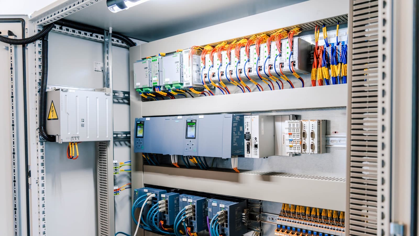 Armoire électrique industrielle ouverte, modules et câblage apparents.