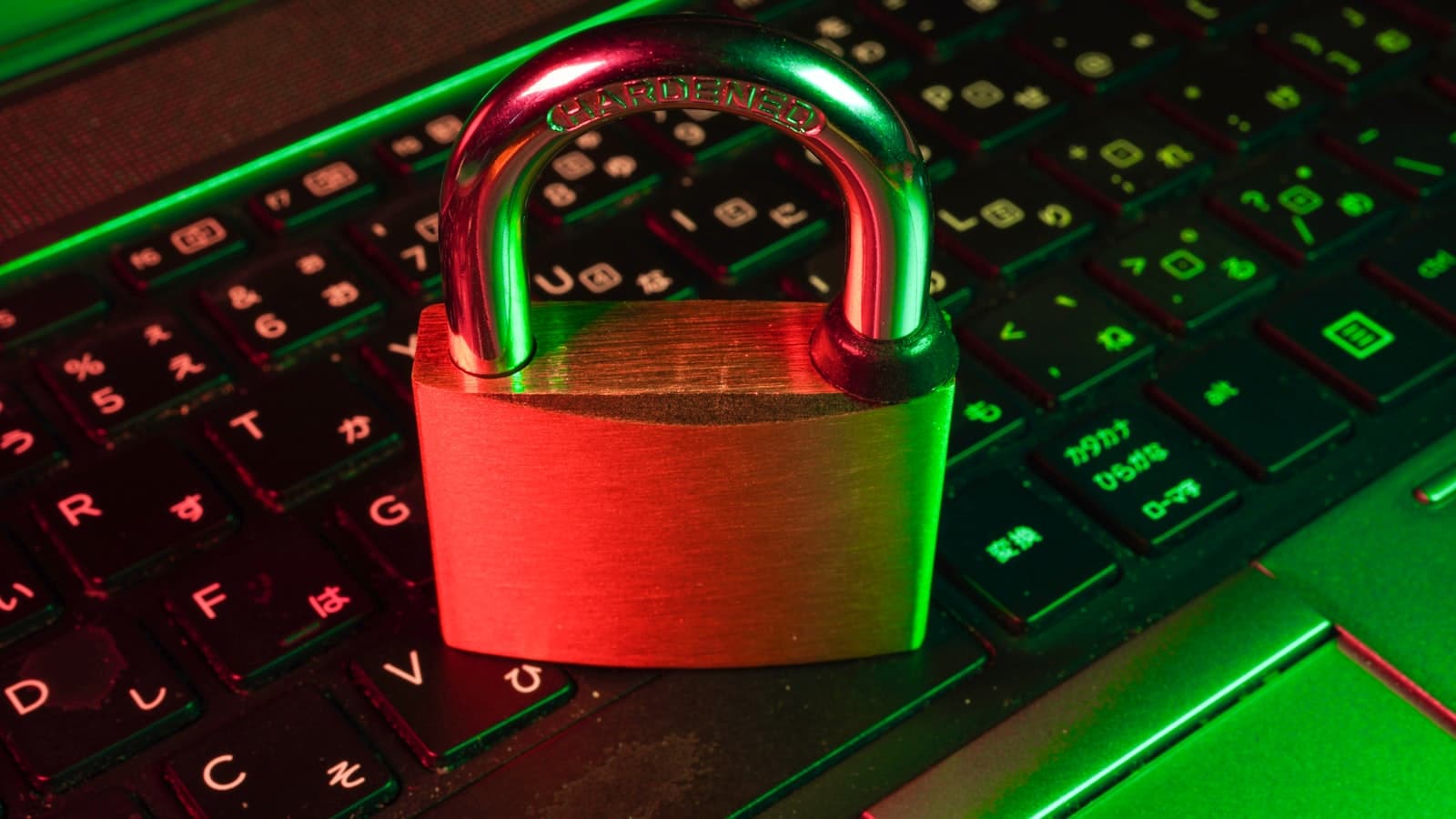 Un cadenas rouge fermé posé sur le clavier noir d'un ordinateur portable.
