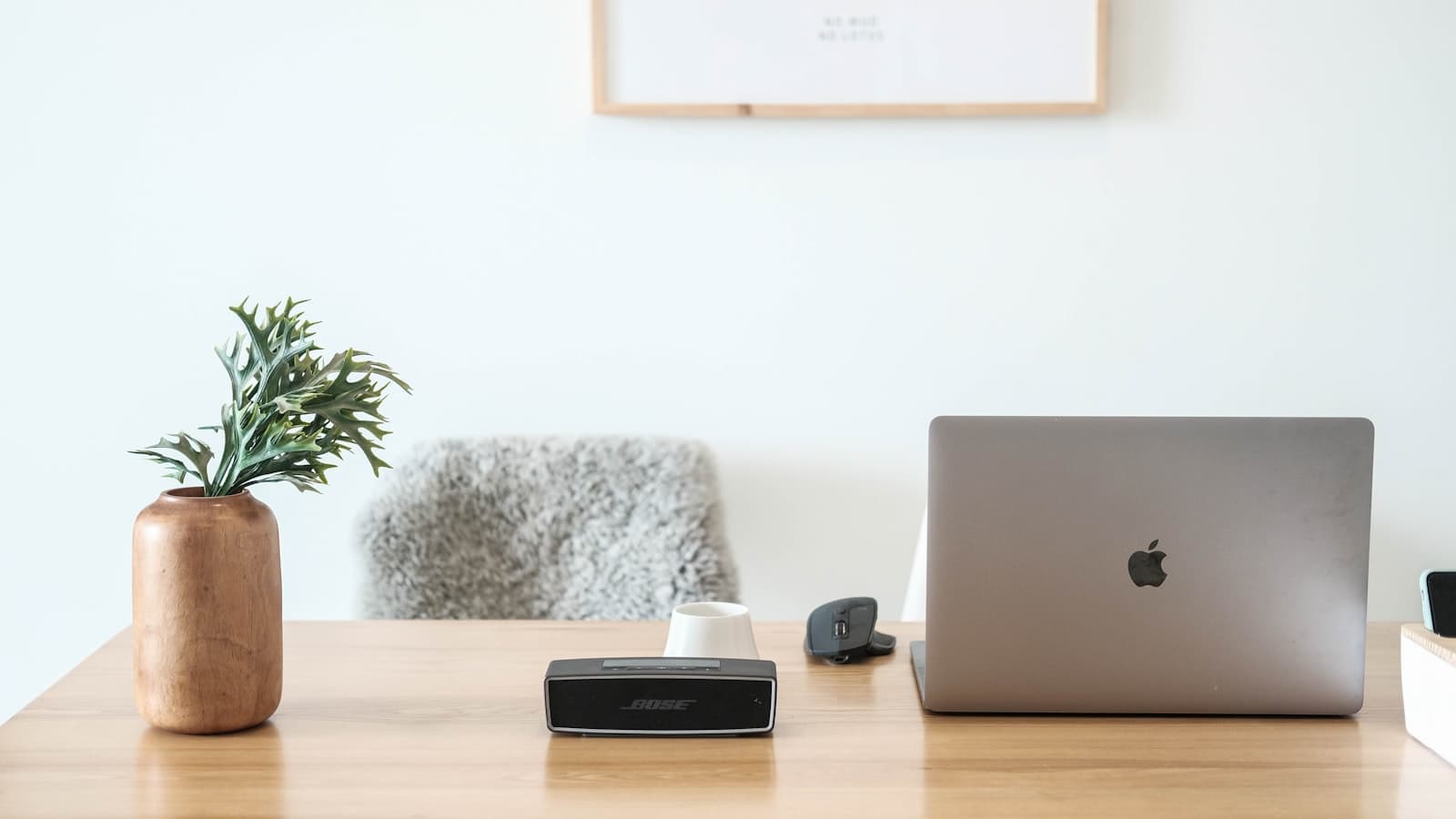 Un MacBook Pro ouvert et posé sur une table en bois, vu de trois quarts.