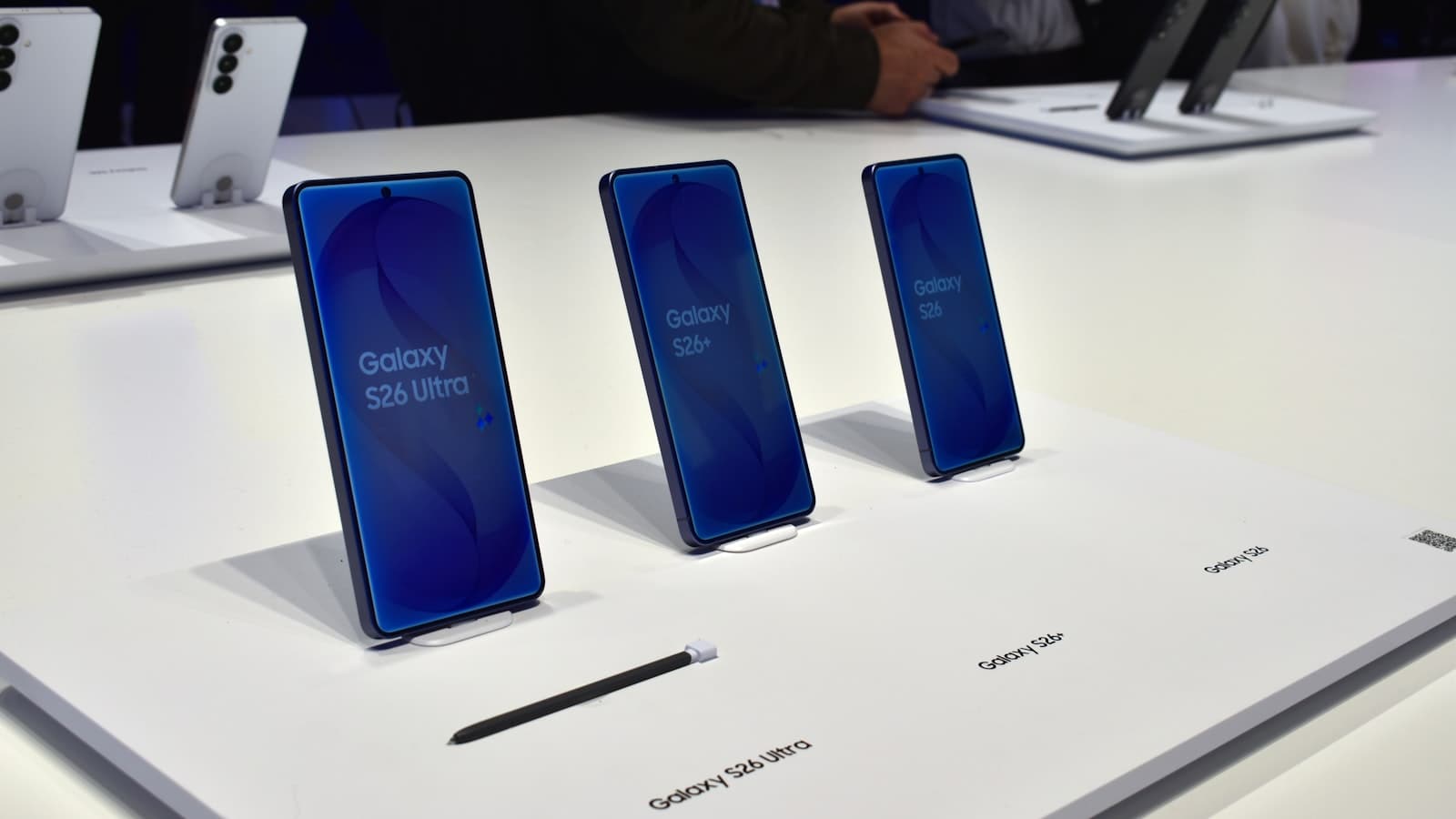 Trois smartphones Samsung Galaxy alignés sur une surface blanche, écrans allumés.